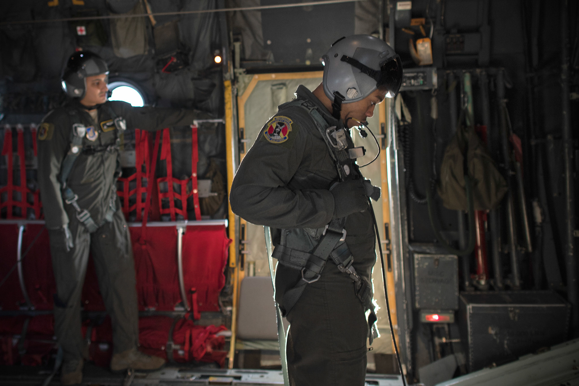Senior Airman Gary Coe, 36th Airlift Squadron C-130H loadmaster, communicates with crew members before opening the rear ramp of a C-130H Hercules aircraft over Yokota Air Base, Japan, Oct. 5, 2017. This is the last time active duty C-130H Hercules' crew members performed a low-cost, low-altitude airdrop. (U.S. Air Force photo by Yasuo Osakabe)