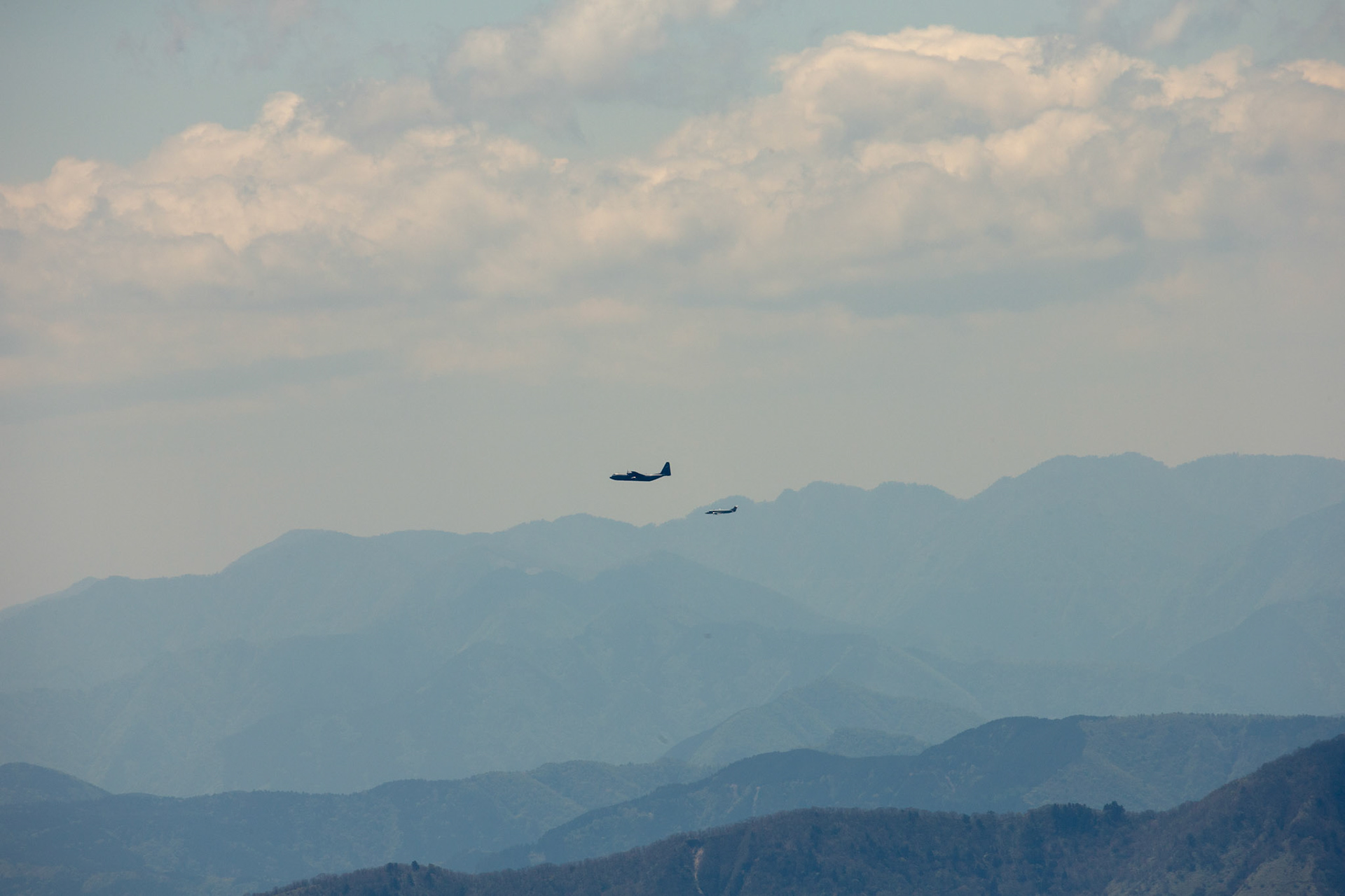 A C-130J Super Hercules, assigned to the 36th Airlift Squadron (AS), and a C-12 Huron, assigned to the 459th AS, fly over mountainous terrain during the 374th Airlift Wing (AW) Generation Exercise at Yamanashi Prefecture, Japan, May 4, 2018. The 374th AW maintains and operates C-130Js, C-12 Hurons, and UH-1Ns, making it the primary Western Pacific airlift hub for U.S. Air Forces during peacetime and contingency operations. (U.S. Air Force photo by Yasuo Osakabe)