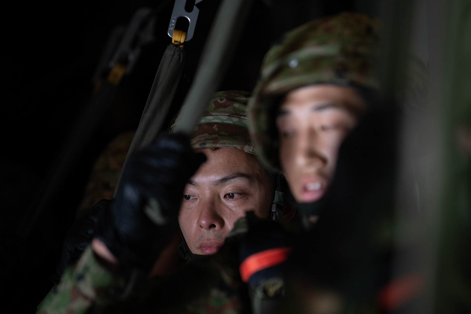 Japan Ground Self-Defense Force soldiers assigned to the 1st Airborne Brigade look outside before conducting a jump from a U.S. Air Force C-130J Super Hercules over Hiju-dai exercise area, Oita prefecture, Japan, July 16, 2019, during a bilateral jump training. The training allows USAF and JGSDF units to work alongside each other while improving the readiness of our armed forces. (U.S. Air Force photo by Yasuo Osakabe)