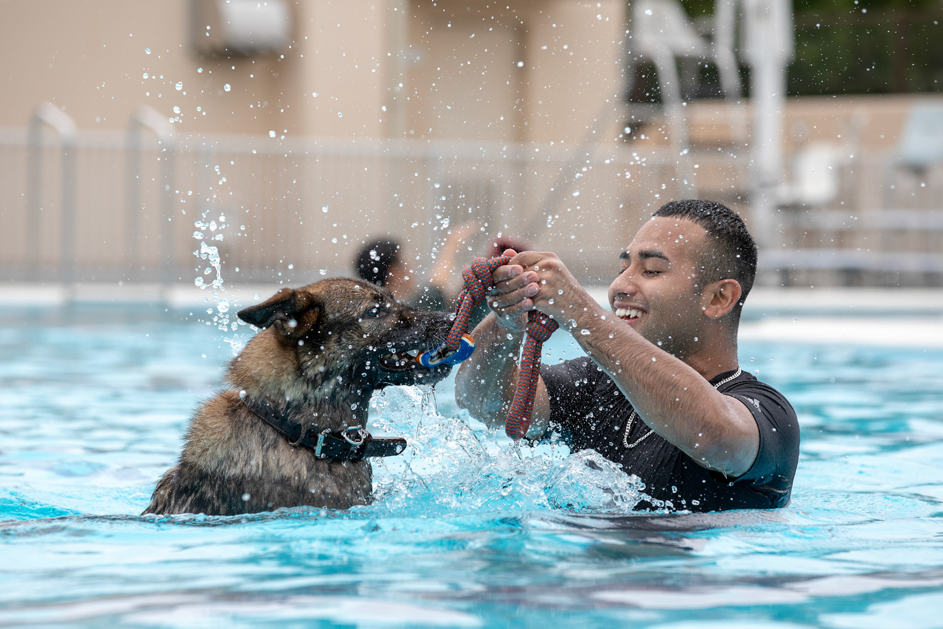 Staff Sgt. Mario Hernandez, 374th Security Forces Squadron military working dog handler, and military working dog Demo play after a water-based aggression training at Yokota Air Base, Japan, Sept. 12, 2018. The water aggression training offers a unique opportunity for working dogs to become familiar with water. (U.S. Air Force photo by Yasuo Osakabe)
