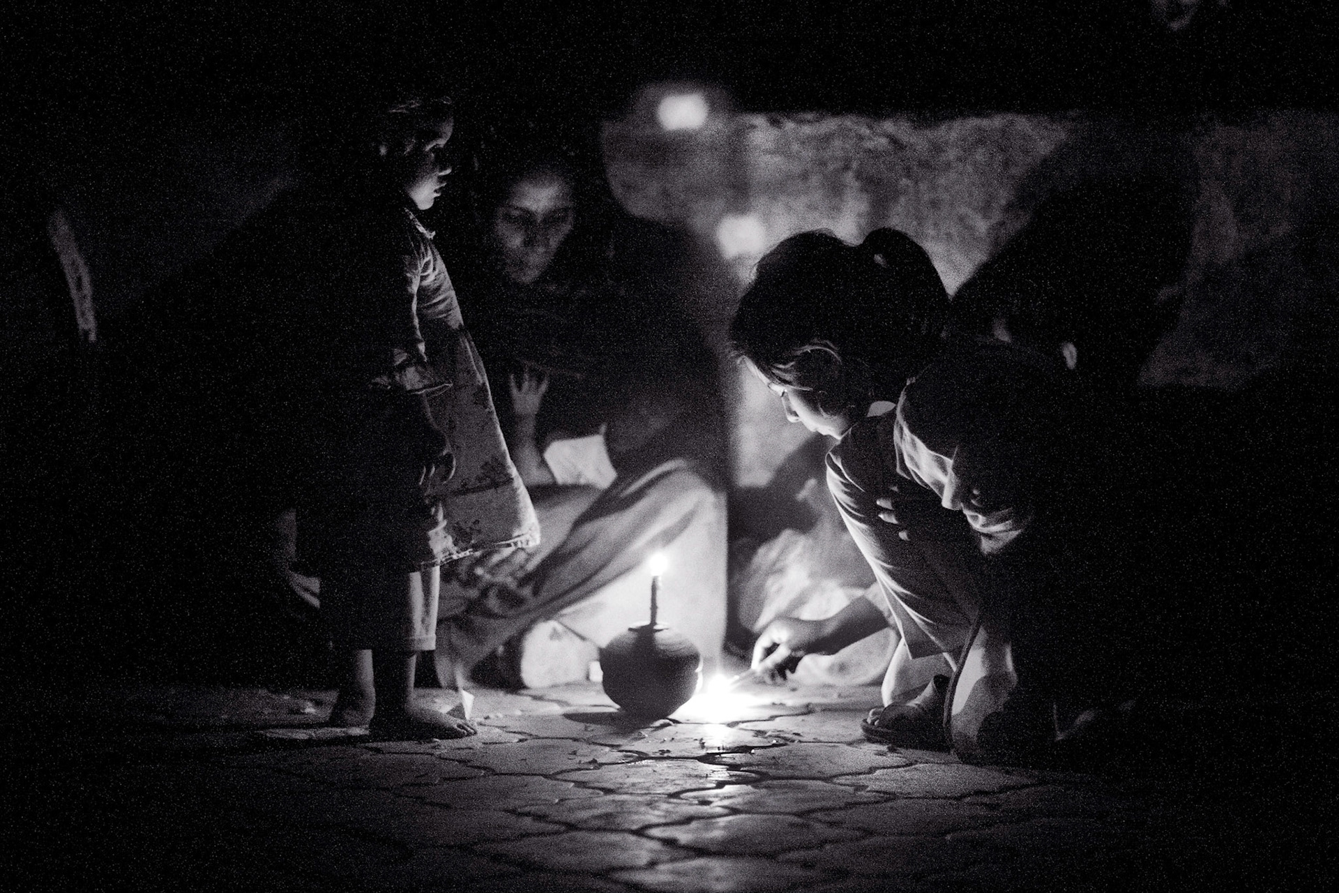 There was a blackout in Lahore almost everyday. A girl lit by glaring candle lights in the shrine of Hazrat Madhu Lal Hussain. (Travel)