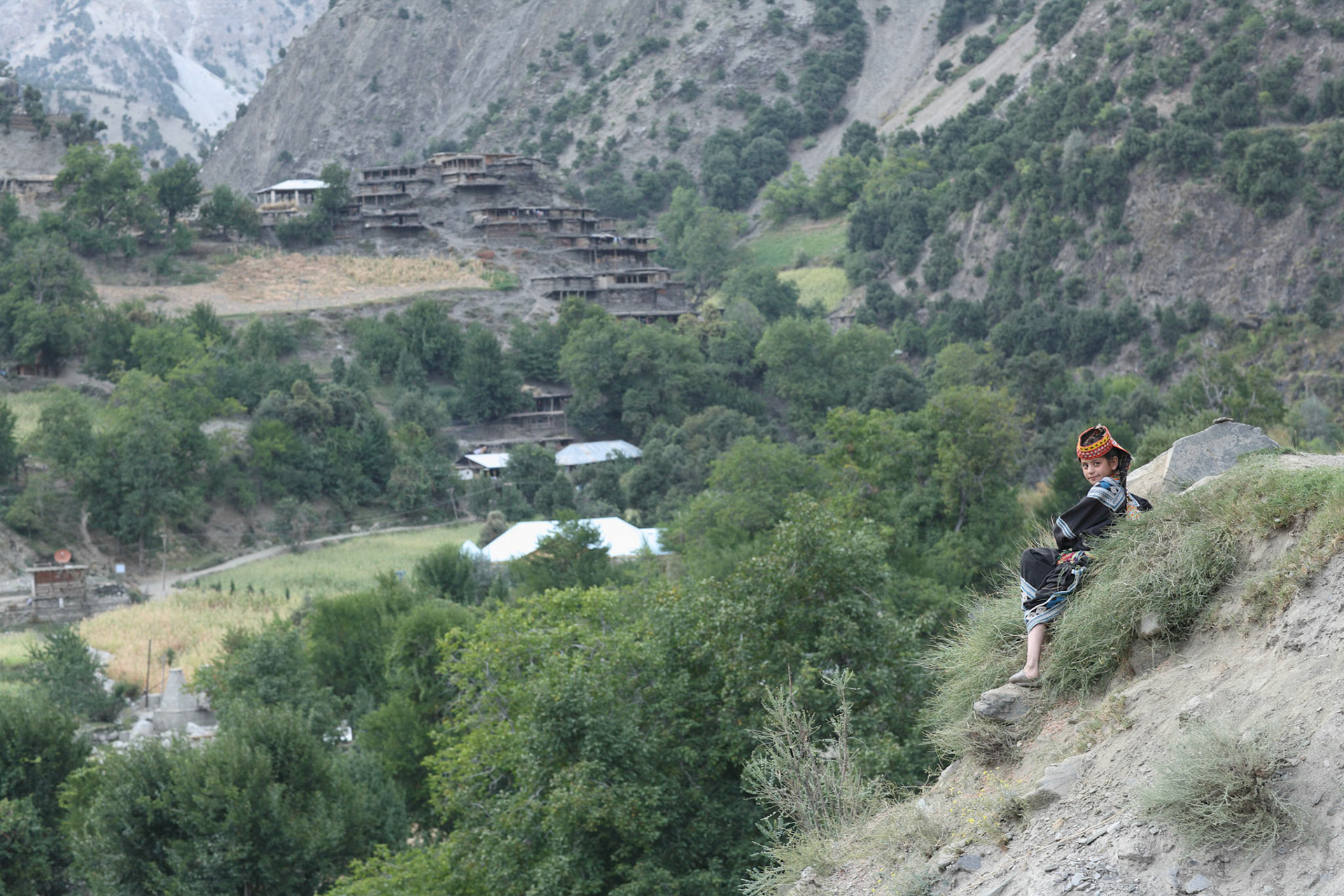 Kalash girl sit by the mountain trail for rest. (Travel)
