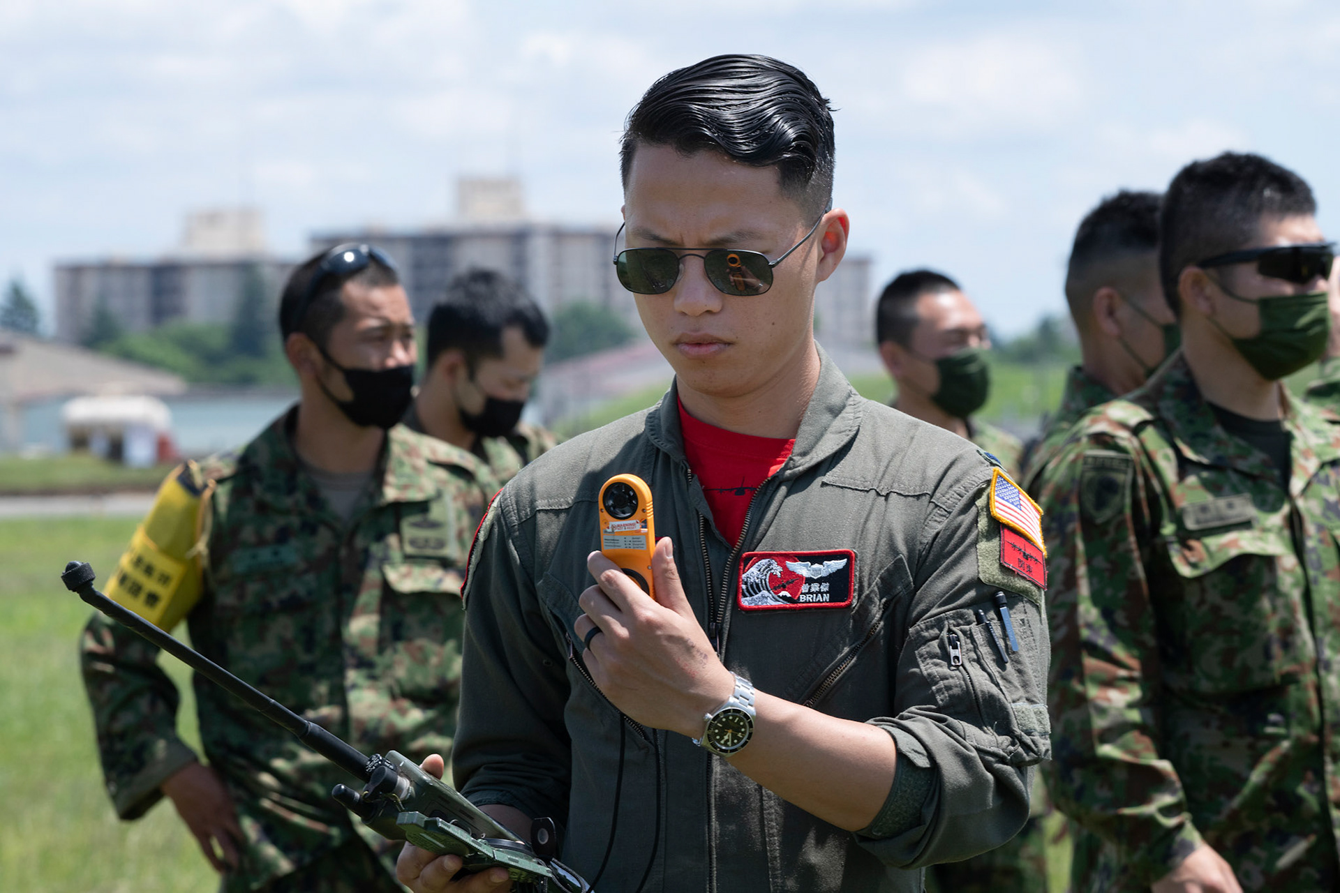 U.S. Air Force 1st Lt. Brian Tang, 36th Airlift Squadron C-130J pilot, collects wind speed data for aircrews in support of a military free fall demonstration during the Japanese-American Friendship Festival at Yokota Air Base, Japan, May 22, 2022. A six member team comprised of U.S. Air Force and JGSDF paratroopers, conducted a military free fall demonstration to show their capabilities during the festival. During the two-day festival, more than 110,000 attendees came to Yokota to experience the event. The festival is aimed at increasing bilateral relationships between U.S. and Japanese communities and allows people to see U.S. and Japanese military capabilities first-hand. (U.S. Air Force photo by Yasuo Osakabe)
