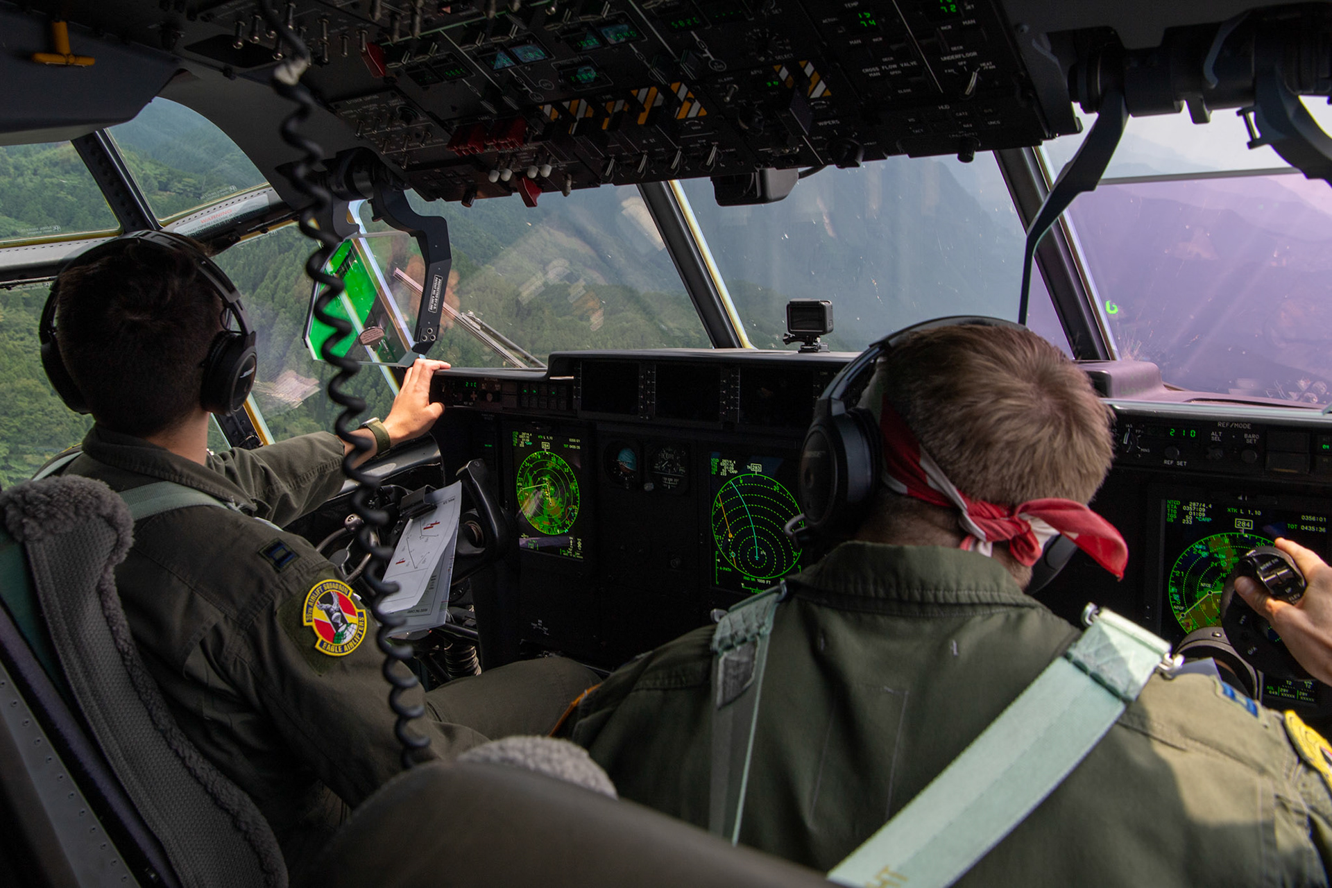 (Left to right) U.S. Air Force Capt. Evan Taylor and Capt. Michael Pyles, 36th Airlift Squadron C-130J pilots, conduct flight training over Mount Aso, Japan, July 16, 2019, during a bilateral jump training. The training allows USAF and JGSDF units to work alongside each other while improving the readiness of our armed forces. (U.S. Air Force photo by Yasuo Osakabe)