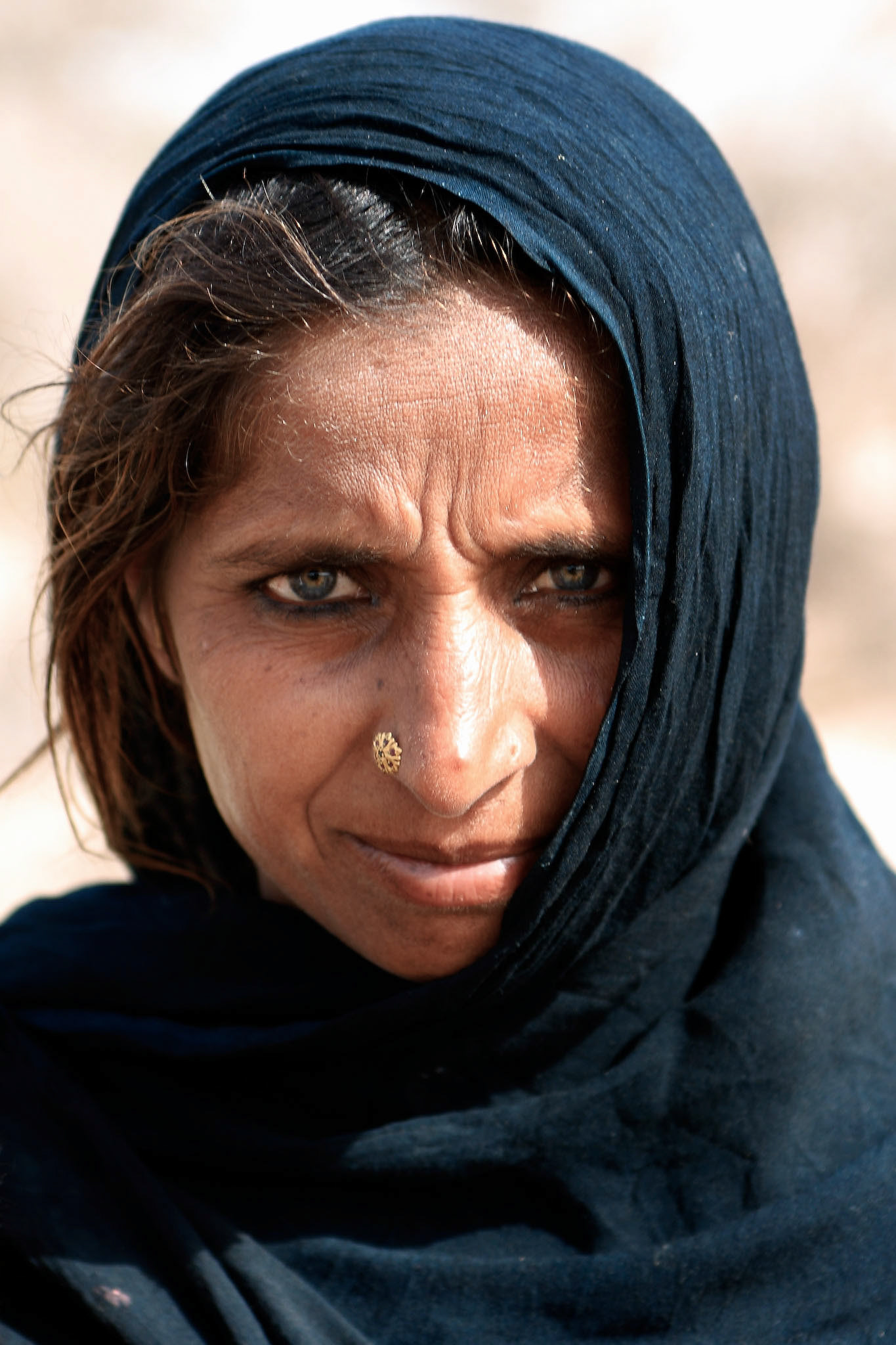 Old woman with piercing blue eyes in Cholistan desert. The tribe is still nomadic in Cholistan desert, Pakistan. (Travel)