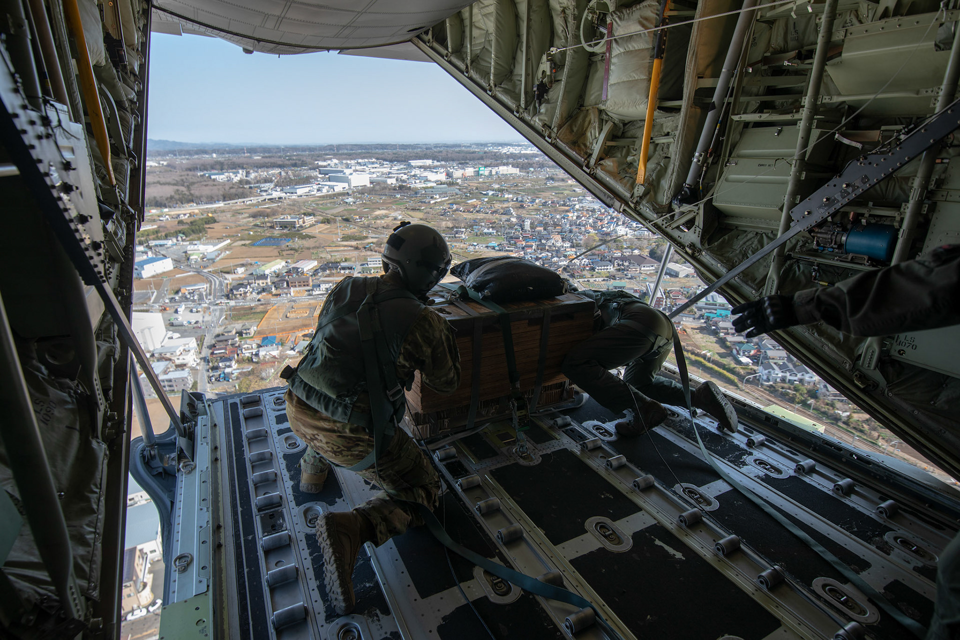 (Left to right) Tech. Sgt. Brian Gates and Airman 1st Class Matthew Pfeffer, 36th Airlift Squadron C-130J loadmasters, prepare to airdrop a low-cost low-altitude bundle during the Yokota C-130J Rodeo over Yokota Air Base, Japan, March 22, 2019. The flight, airdrop, and offload were a part of the Rodeo competition in which pilots and loadmasters are graded on their ability to execute their skillsets both accurately and expeditiously. (U.S. Air Force photo by Yasuo Osakabe)