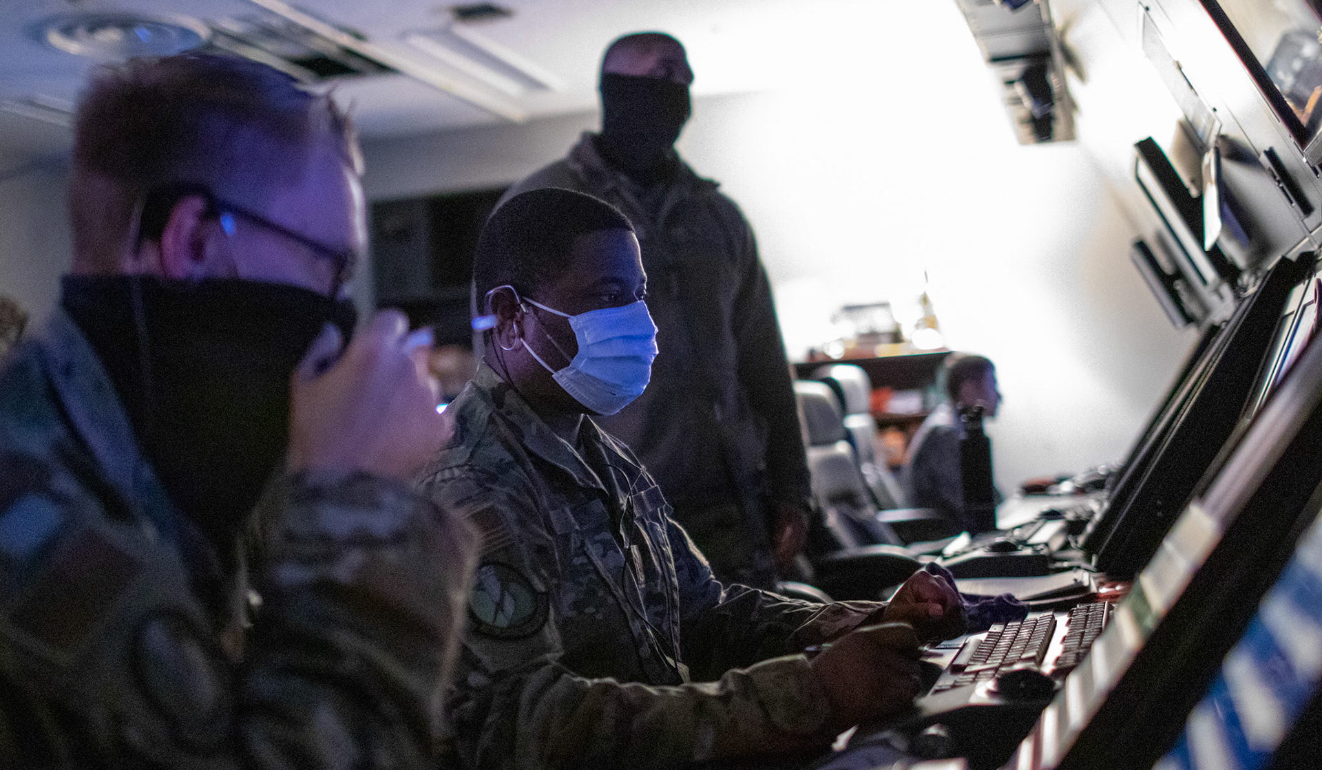 Staff Sgt. Marcus Jenkins, center, 374th Operations Support Squadron radar approach control watch supervisor, reads radar scopes and communicates with pilots flying through the air space, June 11, 2020 at Yokota Air Base, Japan. The RAPCON operates 24/7, 365 days a year to direct all military and civilian aircraft traffic, including fixed-wing and rotary-wing aircraft from the ground to the altitude of 24,000 ft. (U.S. Air Force photo by Yasuo Osakabe)