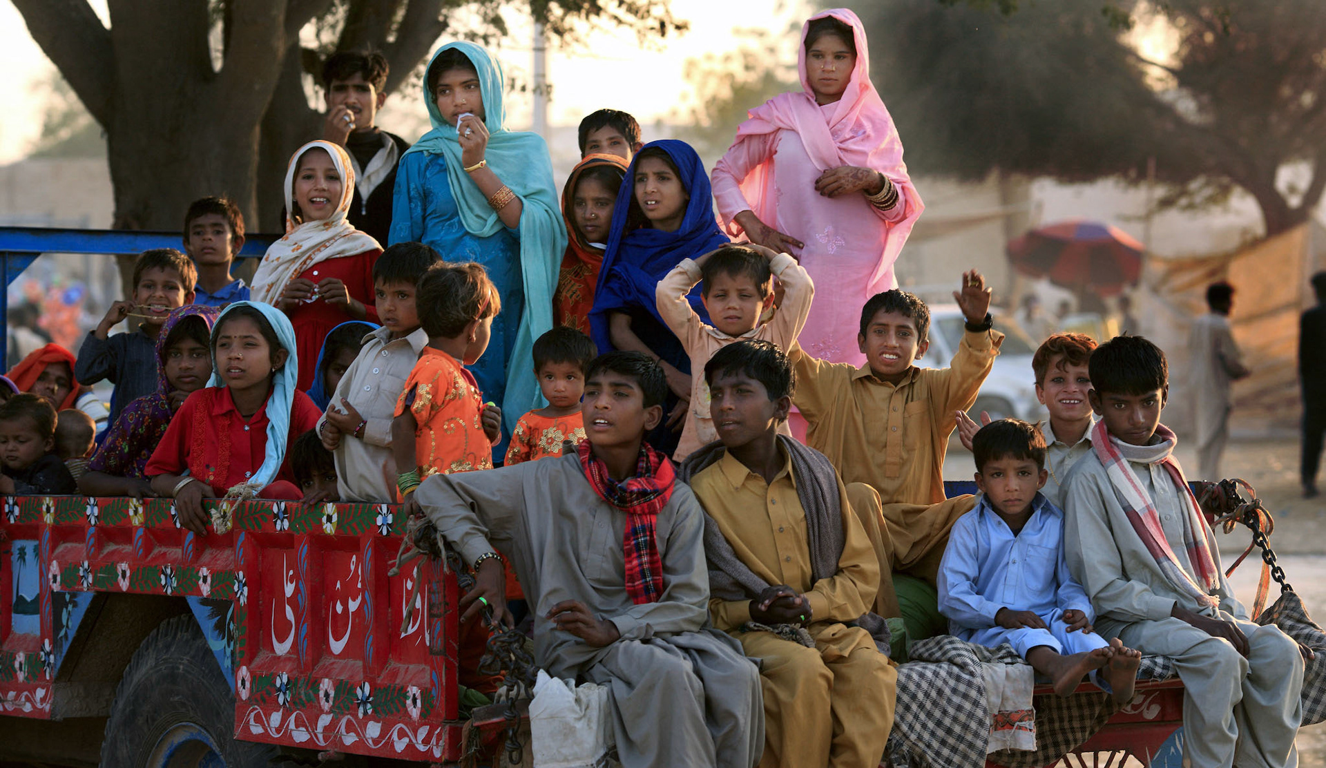 Children had been waiting for departure on the pickup tractor a long time. Suddenly, Dhol players started to beat the drum with a roar on the way to the shrine of channan pir. (Travel)