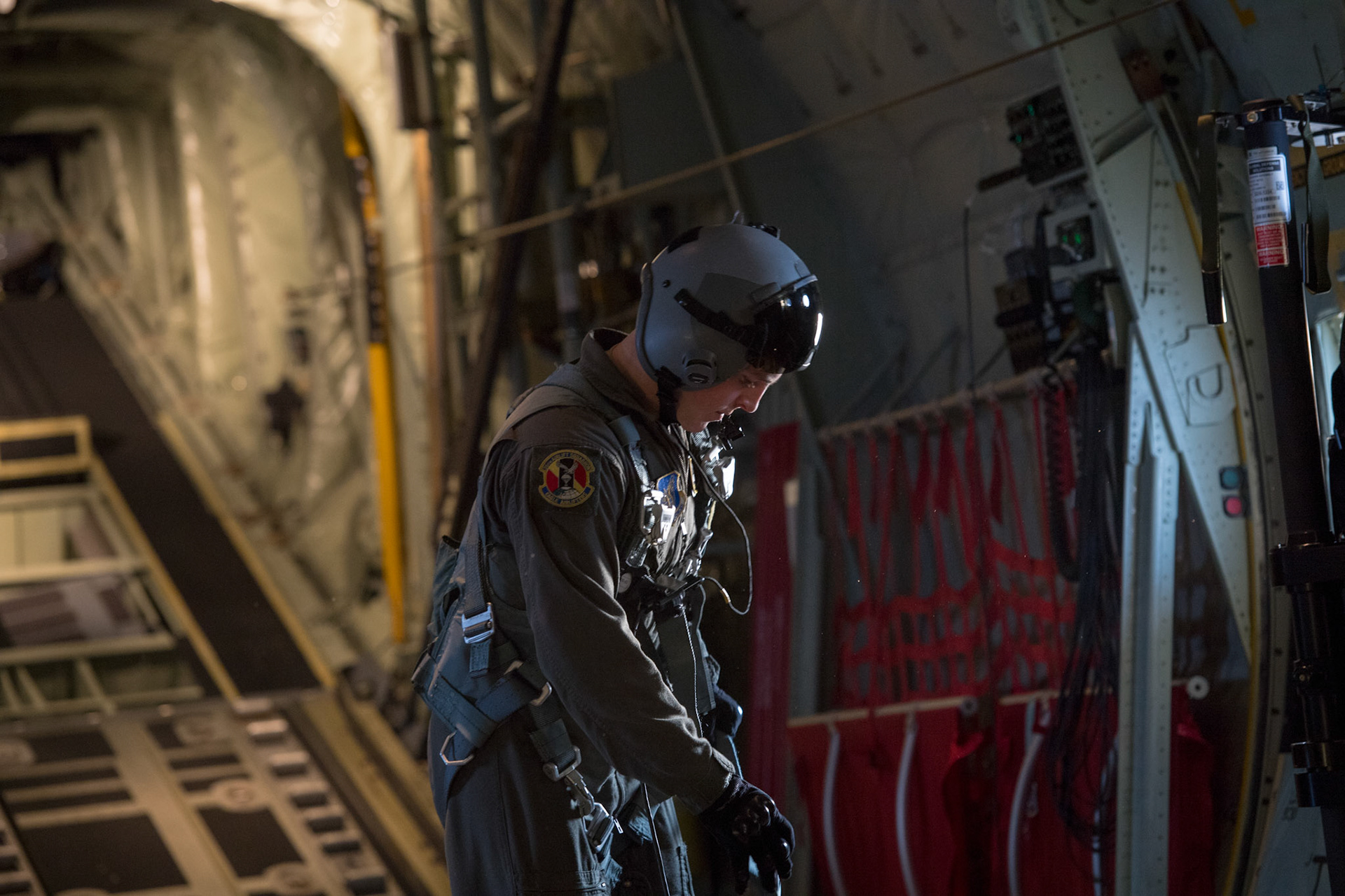 Airman 1st Class Matthew Pfeffer, 36th Airlift Squadron C-130J loadmaster, secures his harness before conducting Container Delivery System (CDS) bundle airdrops over Combined Arms Training Center Camp Fuji, Japan, March 26, 2018. CDS are  most commonly used for quick aerial insertion of supplies for military and contingency operations. Bundles are used as a means of delivering equipment too heavy for the individual jumper to carry. (U.S. Air Force photo by Yasuo Osakabe)