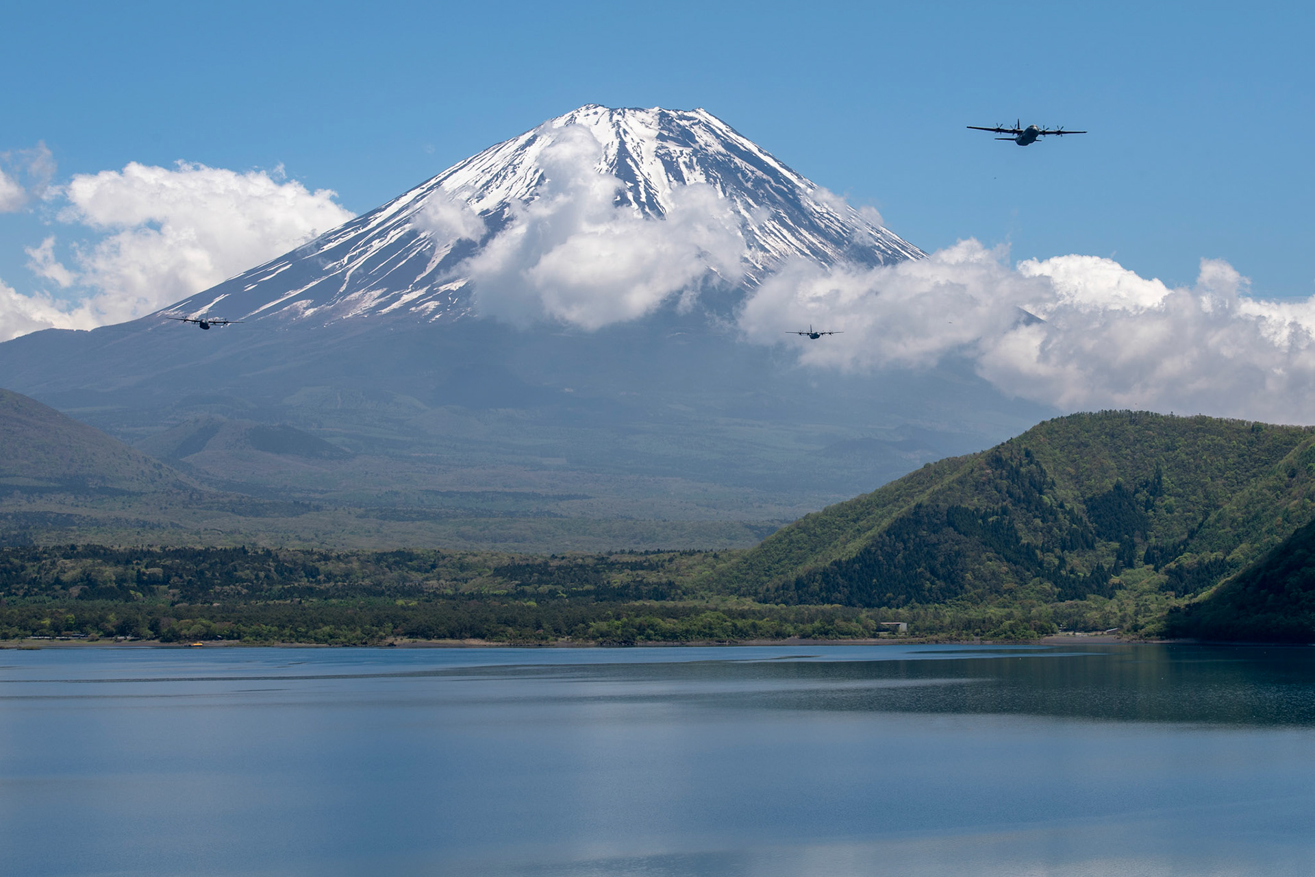 Three C-130J Super Hercules' assigned to the 36th Airlift Squadron fly over Lake Motosu, May 11, 2020, during pre-Samurai Surge training exercise. While COVID-19 has forced teams maintain aircraft and mission plan in a physically distant manner, Yokota’s Samurai Surge serves as proof the pandemic has not altered the 374th Airlift Wing’s mission capability, adaptability and readiness to respond to the needs of the Indo-Pacific region. (U.S. Air Force photo by Yasuo Osakabe)