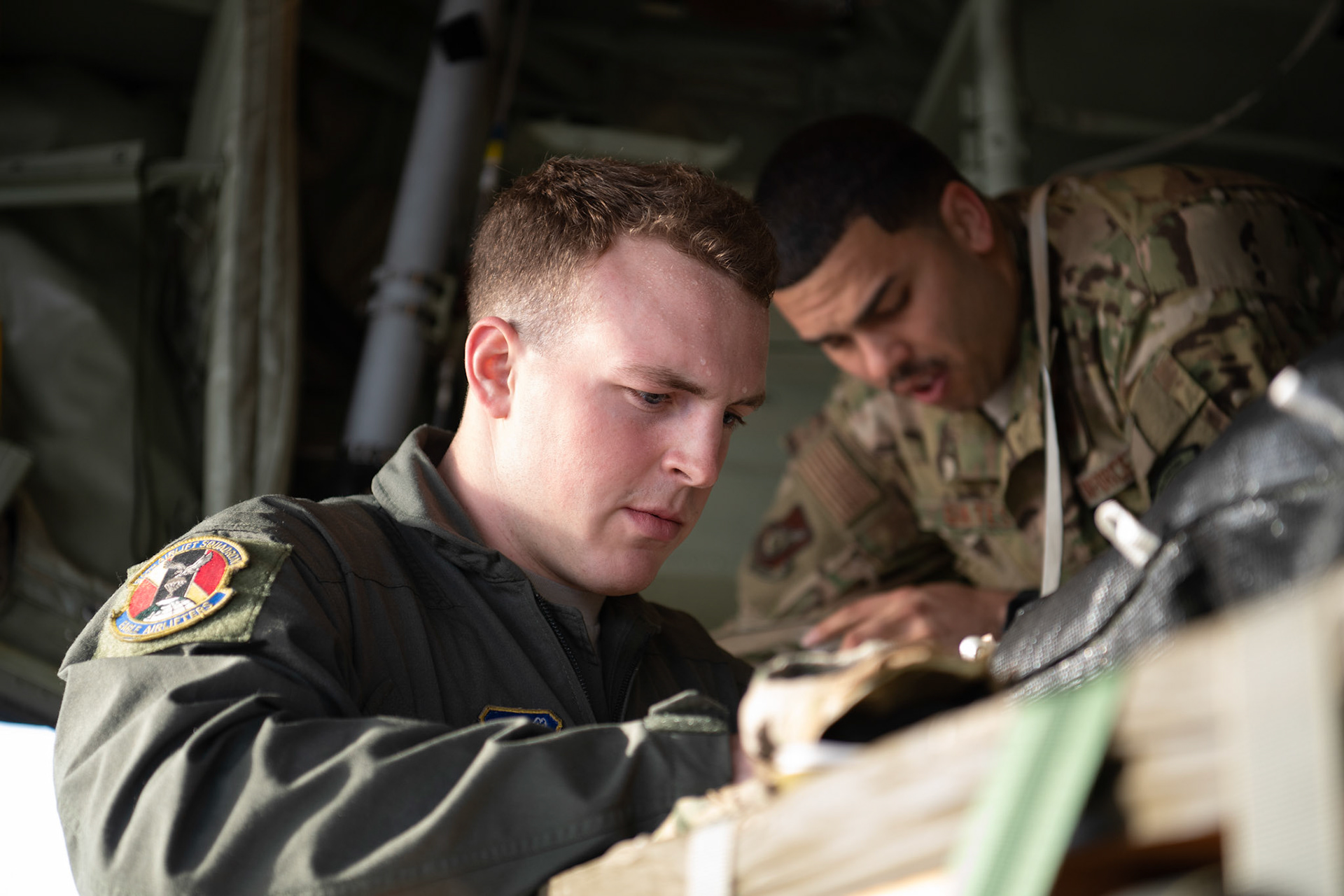 (Front to back) Airman 1st Class Matthew Pfeffer and Tech. Sgt. Brian Gates, 36th Airlift Squadron C-130J loadmasters, rig and inspect a low-cost low-altitude bundle before takeoff at Yokota Air Base, Japan, March 22, 2019. The flight, airdrop, and offload were a part of the Rodeo competition in which pilots and loadmasters are graded on their ability to execute their skillsets both accurately and expeditiously. (U.S. Air Force photo by Yasuo Osakabe)