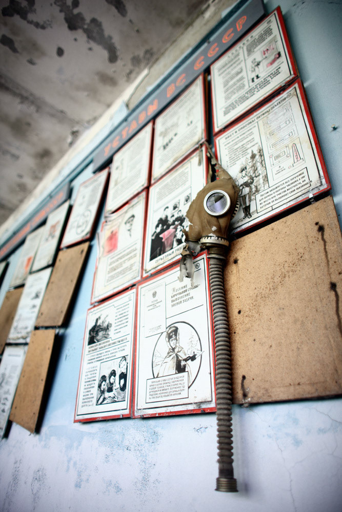 Someone has hanged a gas mask on a bulletin board. It says Sun of the Union of Soviet Socialist Republics statutes.