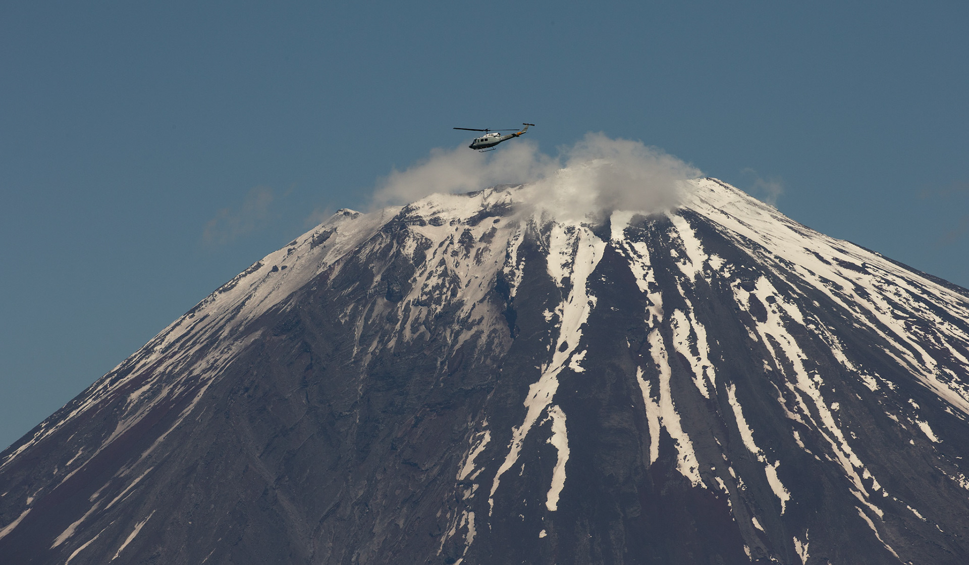 A UH-1N Iroquois assigned to the 459th Airlift Squadron maneuvers over Mount Fuji, Japan, during the 374th Airlift Wing Generation Exercise, May 4, 2018. During the formation flight portion of the exercise, the aircrews flew together over the ocean, through mountainous terrain and dropped sand bags on Yokota’s airfield to test and improve their humanitarian aid and disaster relief capabilities. (U.S. Air Force photo by Yasuo Osakabe)