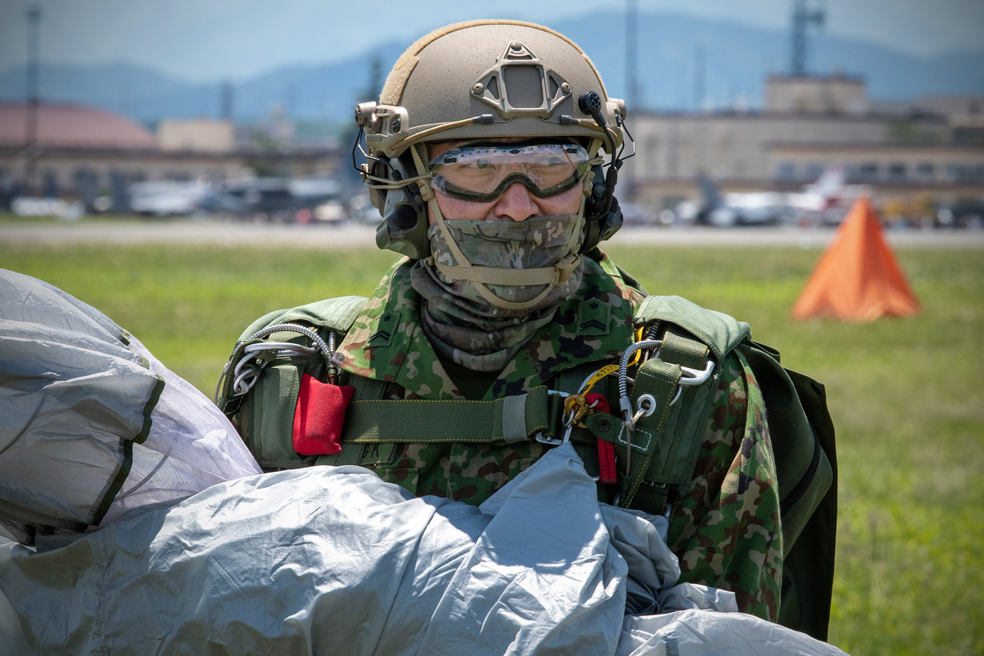 A Japan Ground Self-Defense Force paratrooper assigned to the 1st Airborne Brigade shows his smile after landing at a drop zone during the Japanese-American Friendship Festival at Yokota Air Base, Japan, May 22, 2022. A six member team comprised of U.S. Air Force and JGSDF paratroopers, conducted a military free fall demonstration to show their capabilities during the festival. During the two-day festival, more than 110,000 attendees came to Yokota to experience the event. The festival is aimed at increasing bilateral relationships between U.S. and Japanese communities and allows people to see U.S. and Japanese military capabilities first-hand. (U.S. Air Force photo by Yasuo Osakabe)