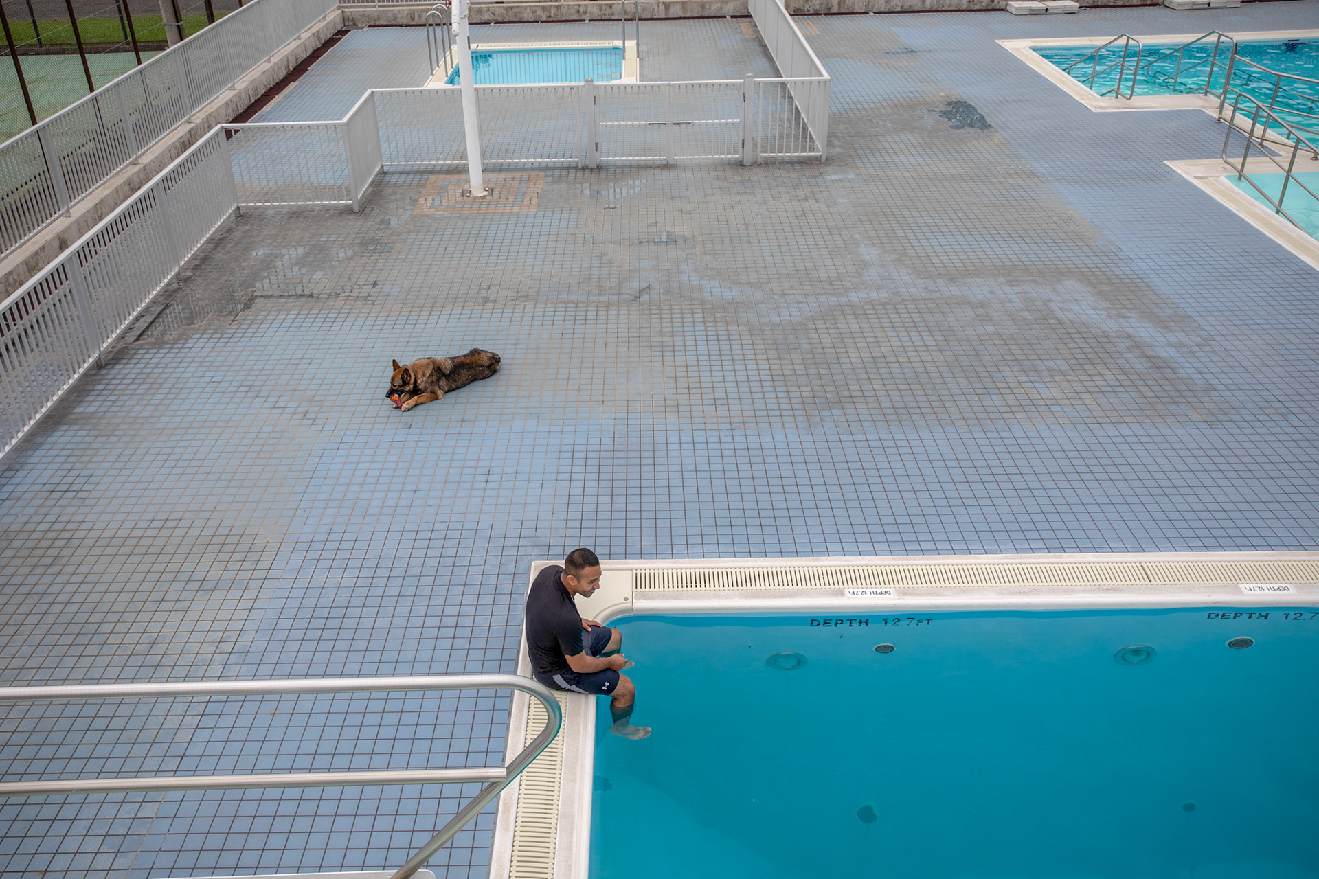 Staff Sgt. Mario Hernandez, 374th Security Forces Squadron military working dog handler, and Demo, 374th SFS military working dog, relax before conducting a water-based aggression training at Yokota Air Base, Japan, Sept. 12, 2018. MWDs performed bite drills designed to slow down or stop suspects attempting to flee apprehension by escaping into a body of water. (U.S. Air Force photo by Yasuo Osakabe)
