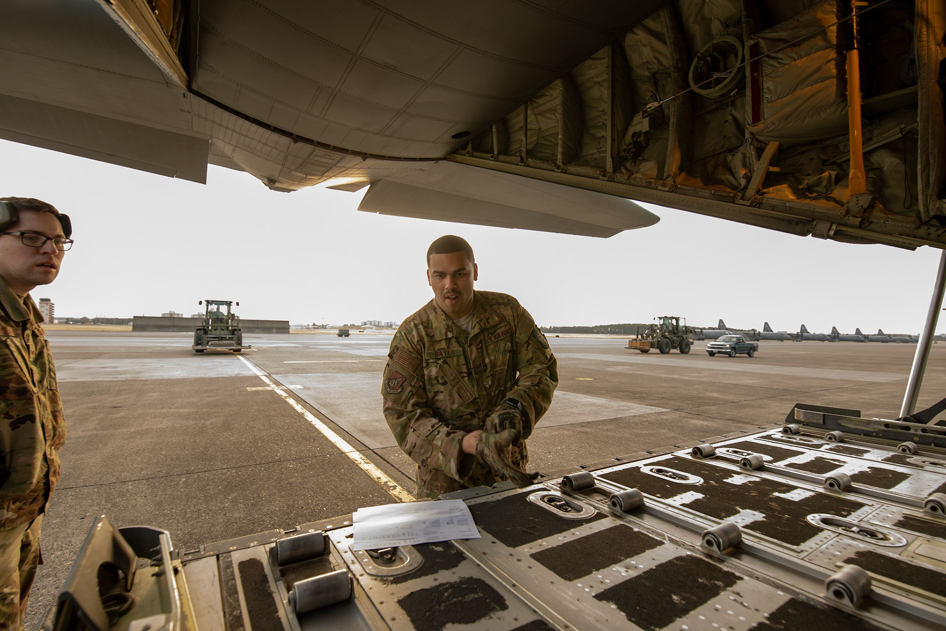 Tech. Sgt. Brian Gates, 36th Airlift Squadron loadmaster, dons a pair of gloves to load pallets onto a C-130J Super Hercules during the Yokota C-130J Rodeo at Yokota Air Base, Japan, March 22, 2019. The Rodeo is a tactical airlift competition between flights within the 36th Airlift Squadron and 374th Operations Support Squadron, whose goal is to demonstrate capabilities, improve procedures, and enhance standardization for global operations.  (U.S. Air Force photo by Yasuo Osakabe)