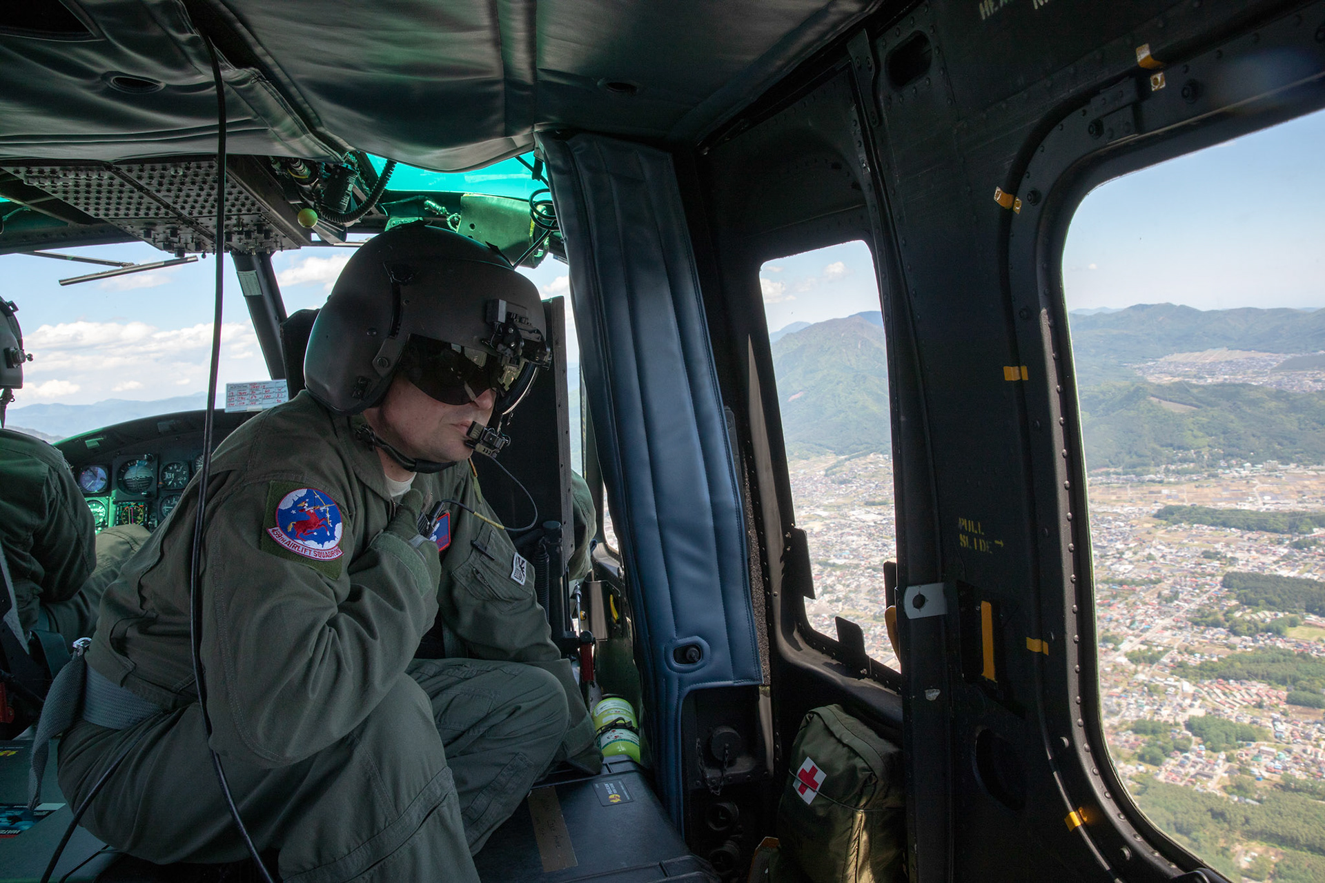 A UH-1N flight engineer from the 459th Airlift Squadron communicates with his crewmembers during the 374th Airlift Wing Generation Exercise at Shizuoka Prefecture, Japan, May 4, 2018. This part of the exercise was conducted in order to demonstrate the wing’s ability to complete a formation flight with multiple aircraft. (U.S. Air Force photo by Yasuo Osakabe)