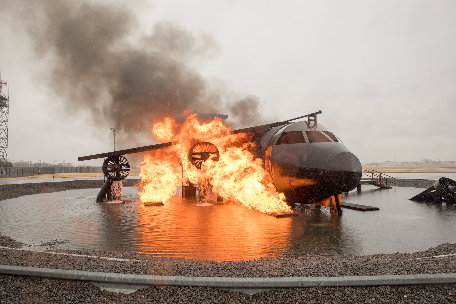 The 374th Civil Engineer Squadron fire and emergency services flight conduct live-fire training with an aircraft fire simulator at Yokota Air Base, Japan, March 8, 2018. Yokota firefighters and the 374th Maintenance Squadron repair and reclamation section conduct live-fire training to keep Airmen ready for a real-world emergency. (U.S. Air Force photo by Yasuo Osakabe)