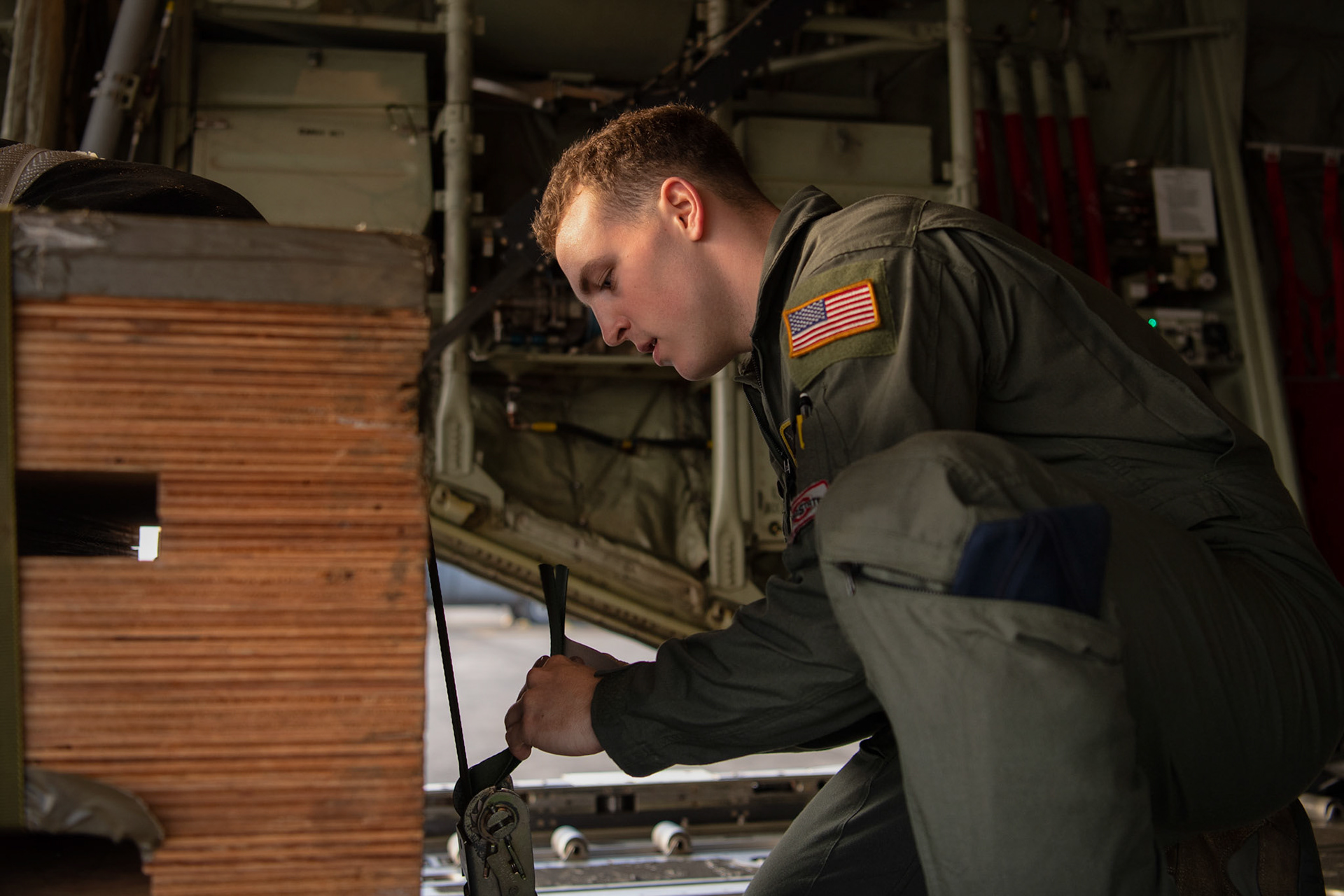 Airman 1st Class Matthew Pfeffer, 36th Airlift Squadron C-130J loadmaster, secures a low-cost low- altitude bundle during the Yokota C-130J Rodeo at Yokota Air Base, Japan, March 22, 2019. The flight, airdrop, and offload were a part of the Rodeo competition in which pilots and loadmasters are graded on their ability to execute their skillsets both accurately and expeditiously. (U.S. Air Force photo by Yasuo Osakabe)