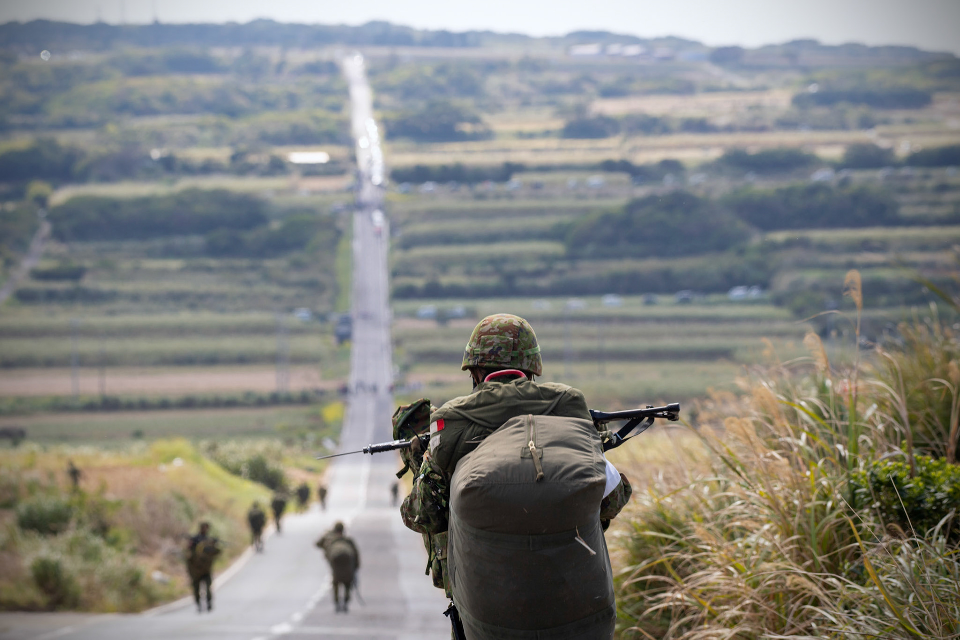 A Japan Ground Self-Defense Force paratrooper assigned to the 1st Airborne Brigade carries his equipment after landing at Kikaijima Island, Japan, March 3, 2023, during Field Training Exercise Iron Fist 23.  During the exercise, the USAF and Japan Self-Defense Forces conducted simulated island seizure airborne operations as the U.S. Marine Corps performed a simultaneous amphibious assault onto the beachhead. (U.S. Air Force photo by Yasuo Osakabe)