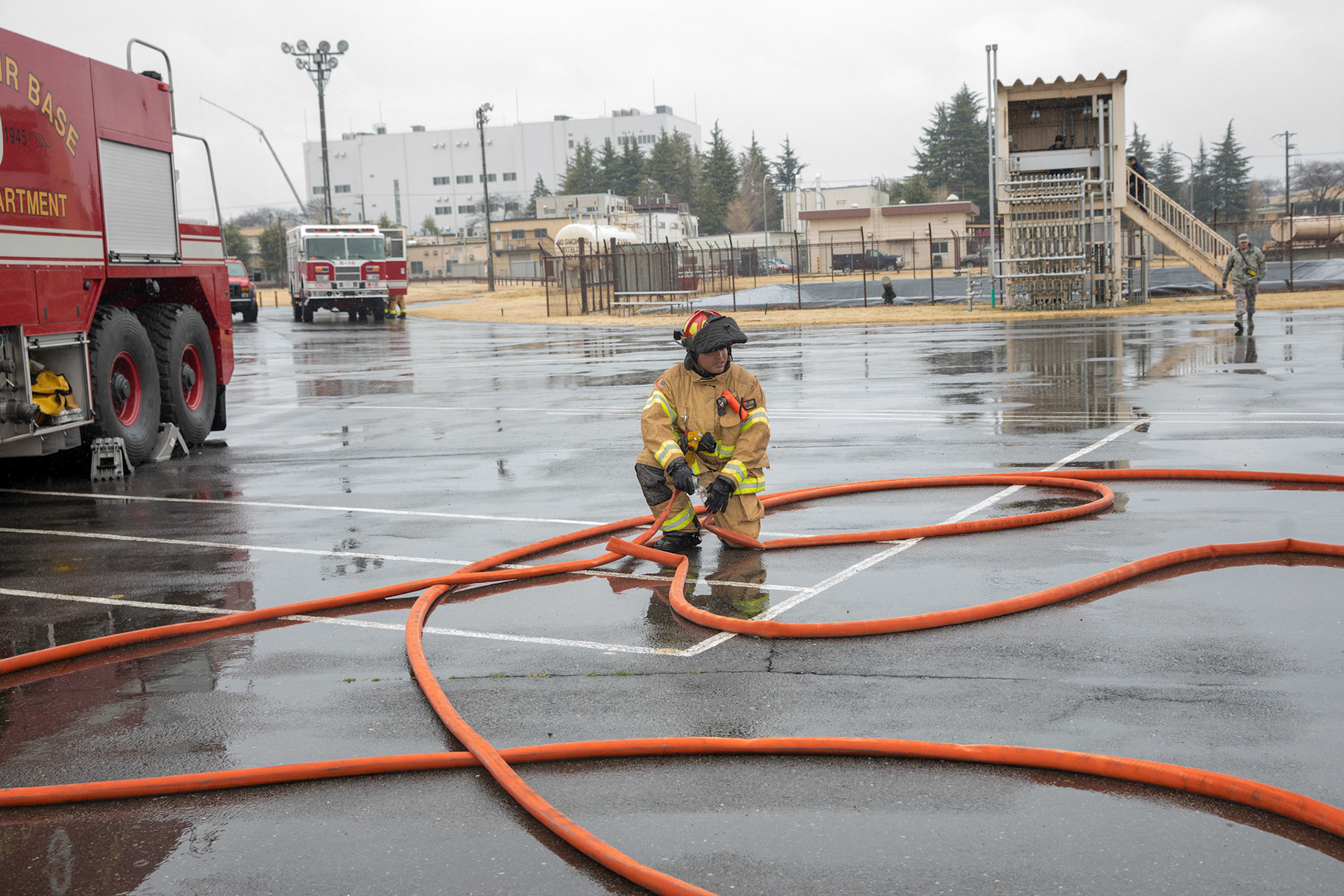 Staff Sgt. Trevor Alexis, 374th Civil Engineer Squadron firefighter, straightens out a hose after battling a simulated aircraft fire at Yokota Air Base, Japan, March 8, 2018. Aircraft live-fire training is conducted periodically throughout the year to ensure Airmen and civilians with the 374th CES and 374th Maintenance Squadron repair and reclamation section are always prepared to combat aircraft fuel fires. (U.S. Air Force photo by Yasuo Osakabe)
