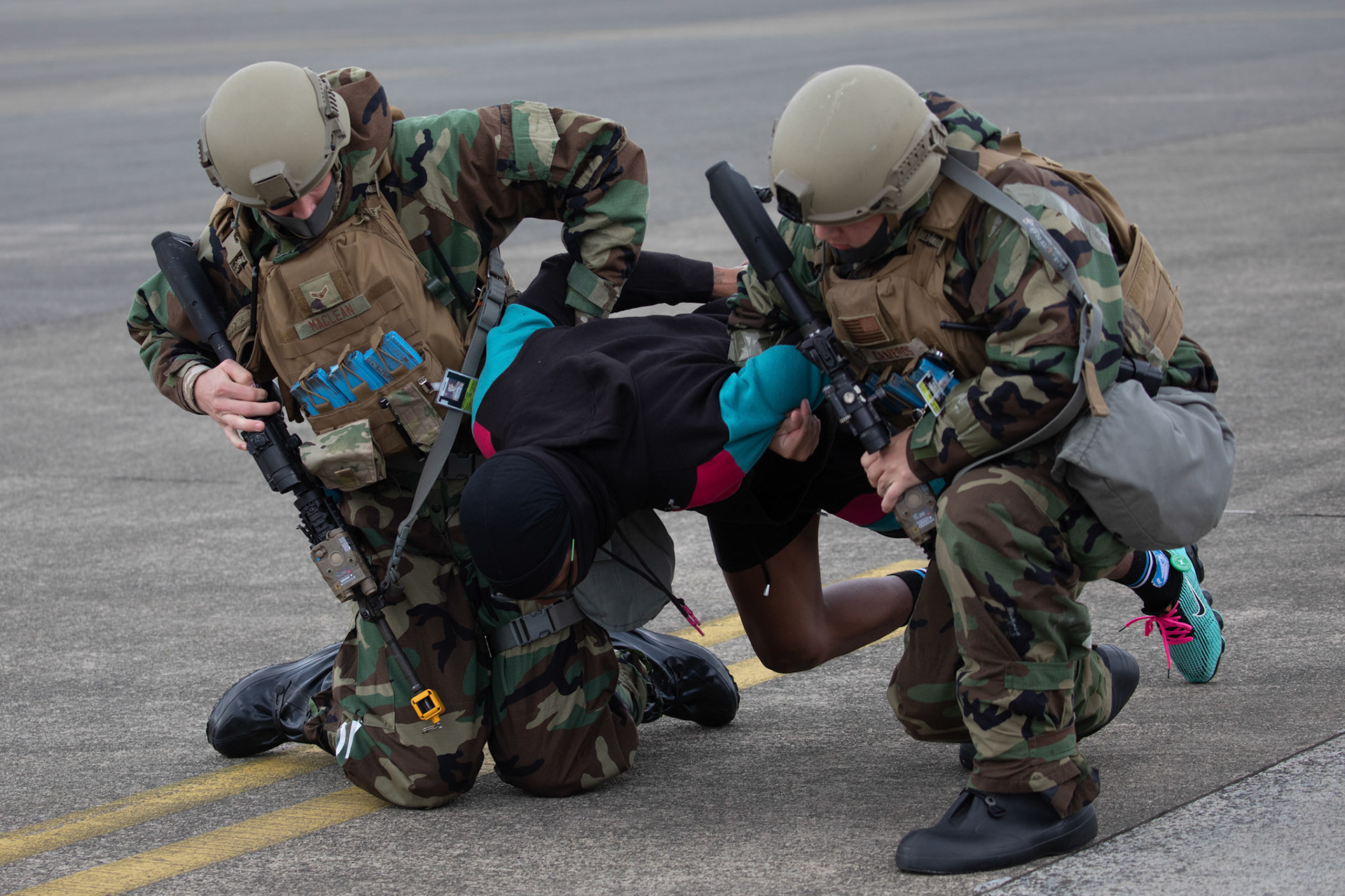 (Left to right) Airman 1st Class John Maclean and Gerardo Cameros, both with the 374th Security Forces Squadron patrolmen, secure a simulated hostage during an anti-hijacking exercise at Yokota Air Base, Japan, May 5, 2021. Team Yokota members participated in a two-week-long Samurai Readiness Inspection exercise which ensures the base is ready to respond to potential contingencies in the area. (U.S. Air Force photo by Yasuo Osakabe)