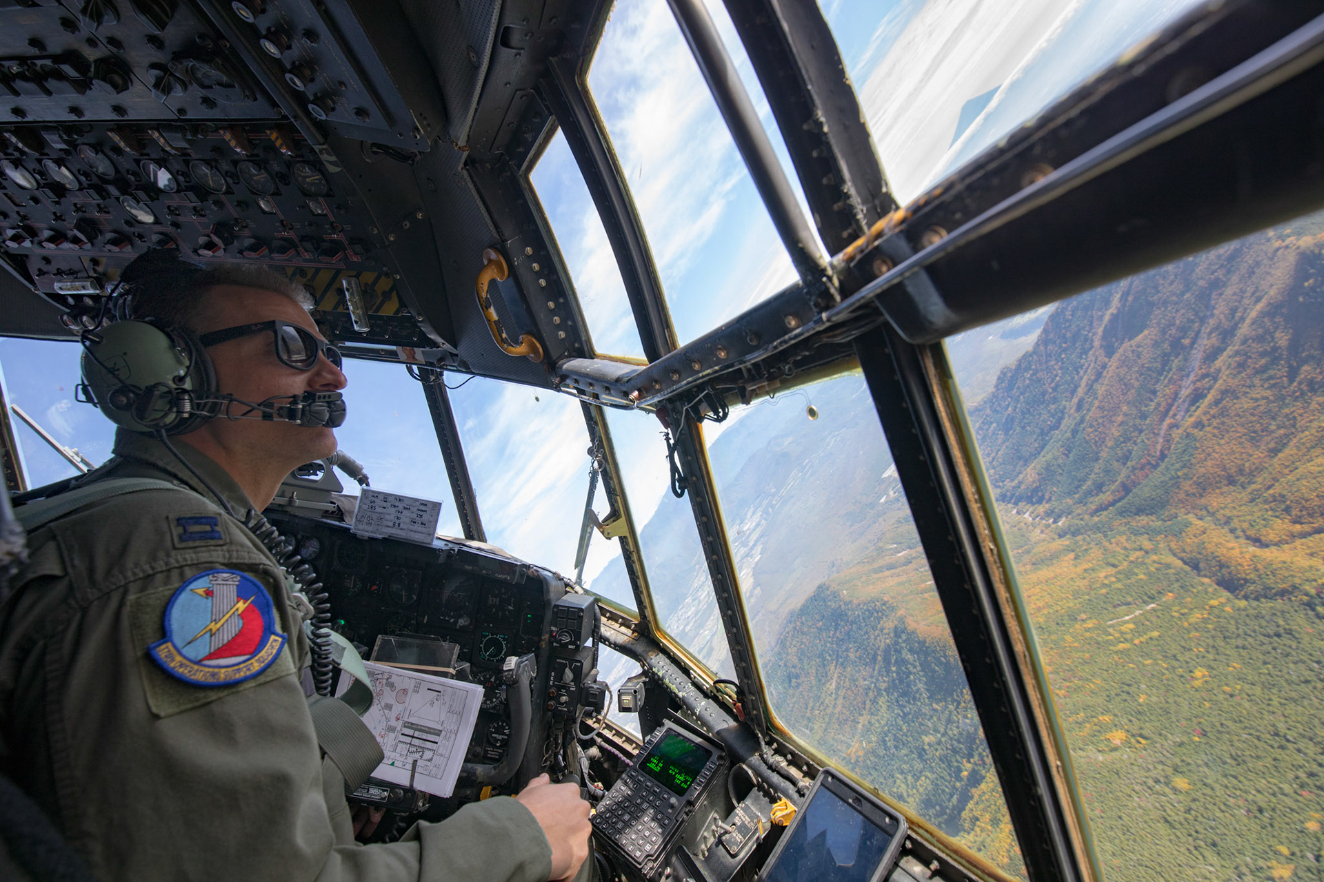 Capt. Thomas Bernard, 36th Airlift Squadron C-130H pilot, performs visual confirmation during a tactical training sortie, over Yamanashi Prefecture, Japan, Oct. 5, 2017. This is the last active duty C-130H Hercules tactical training sortie. (U.S. Air Force photo by Yasuo Osakabe)