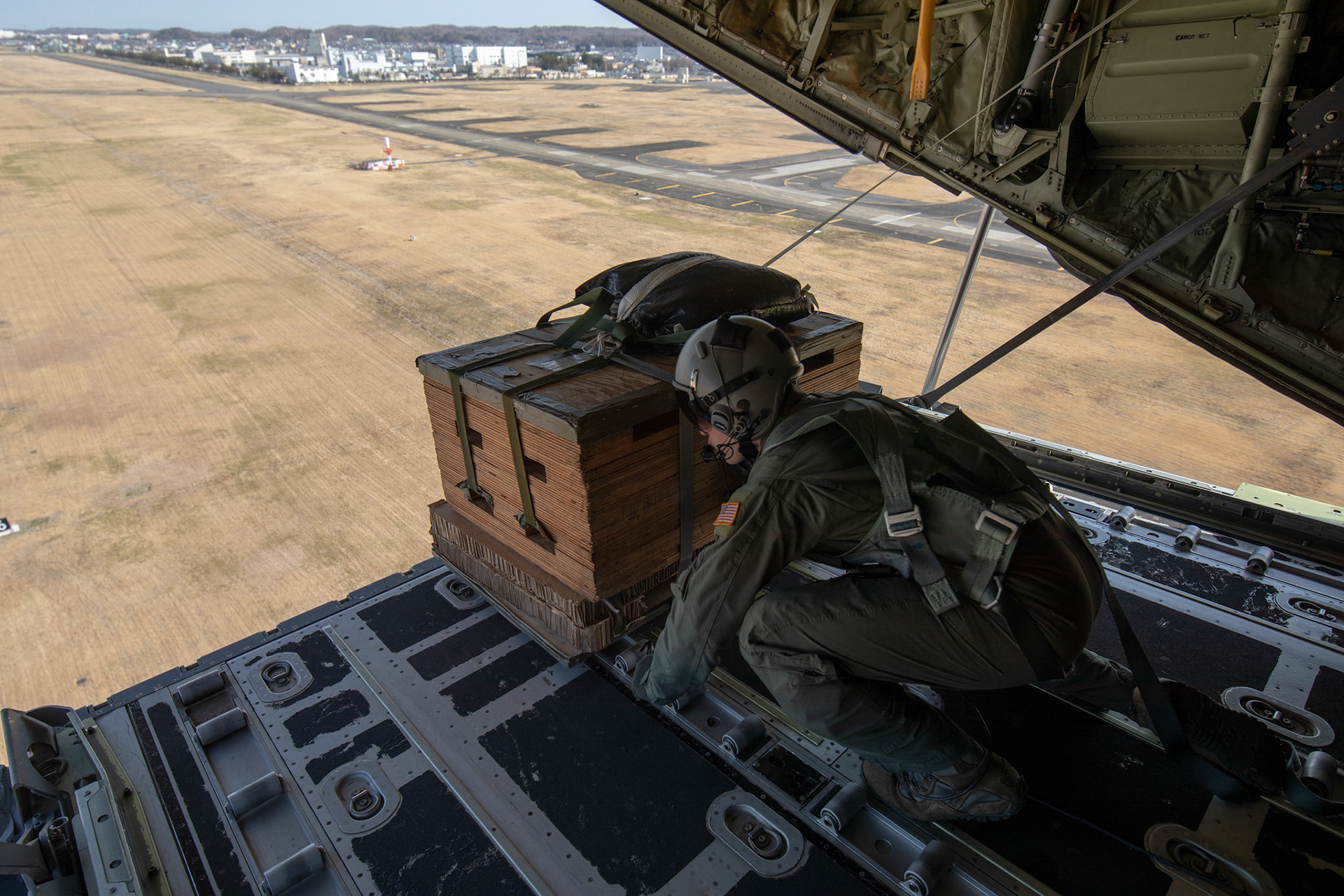 Airman 1st Class Matthew Pfeffer, 36th Airlift Squadron C-130J loadmaster, performs a low-cost low-altitude bundle airdrop on a marked target during the Yokota C-130J Rodeo March 22, 2019, over Yokota Air Base, Japan. The 36th Airlift Squadron held a tactical airlift Rodeo competition to test and improve combat tactics in a competitive environment with a split focus on pilot and loadmaster skills. (U.S. Air Force photo by Yasuo Osakabe)