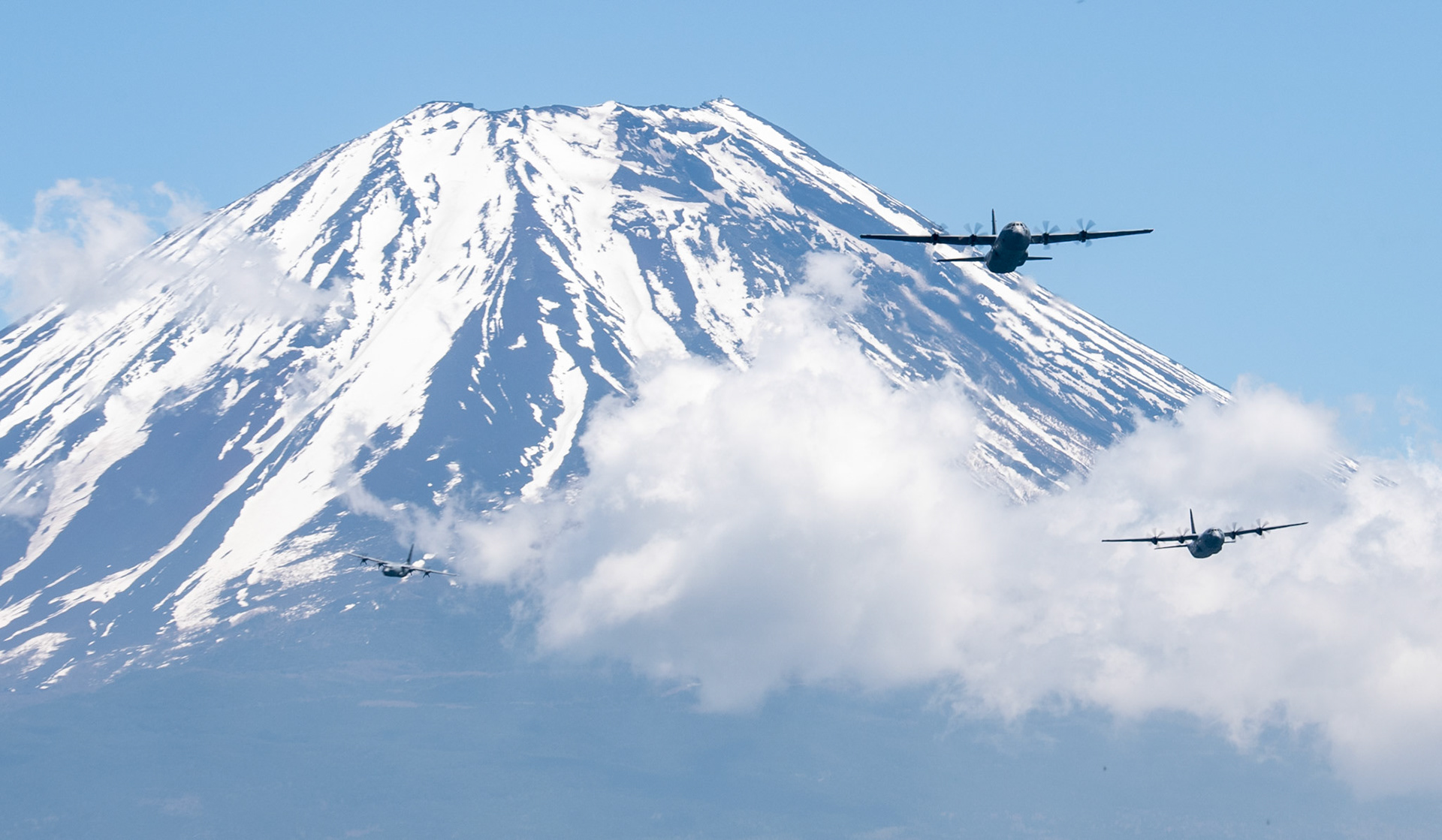 Three C-130J Super Hercules' assigned to the 36th Airlift Squadron fly over Mount Fuji, May 11, 2020, during pre-Samurai Surge training exercise. While COVID-19 has forced teams maintain aircraft and mission plan in a physically distant manner, Yokota’s Samurai Surge serves as proof the pandemic has not altered the 374th Airlift Wing’s mission capability, adaptability and readiness to respond to the needs of the Indo-Pacific region. (U.S. Air Force photo by Yasuo Osakabe)
