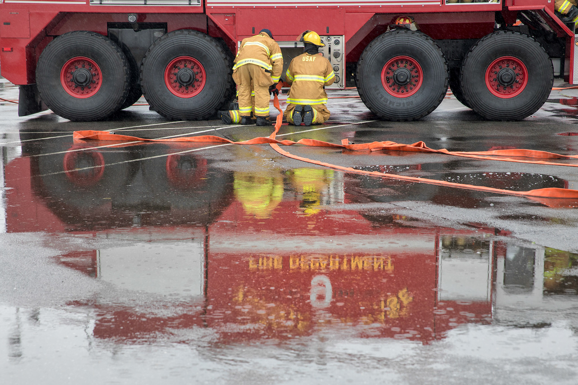 Firefighters assigned to the 374th Civil Engineer Squadron pack away hoses after conducting a simulated aircraft fire drill at Yokota Air Base, Japan, March 8, 2018. Aircraft live-fire training is conducted periodically throughout the year to ensure Airmen and civilians with the 374th CES and 374th Maintenance Squadron repair and reclamation section are always prepared to combat aircraft fuel fires. (U.S. Air Force photo by Yasuo Osakabe)