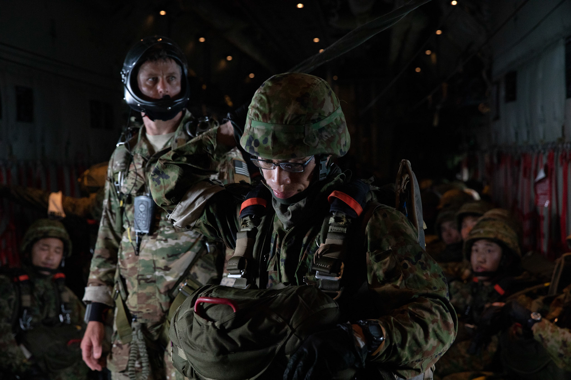 A Japan Ground Self-Defense Force solider assigned to the 1st Airborne Brigade secures his jump gear over Hiju-dai exercise area, Oita prefecture, Japan, July 16, 2019, during a bilateral jump training. The training allows USAF and JGSDF units to work alongside each other while improving the readiness of our armed forces. (U.S. Air Force photo by Yasuo Osakabe)