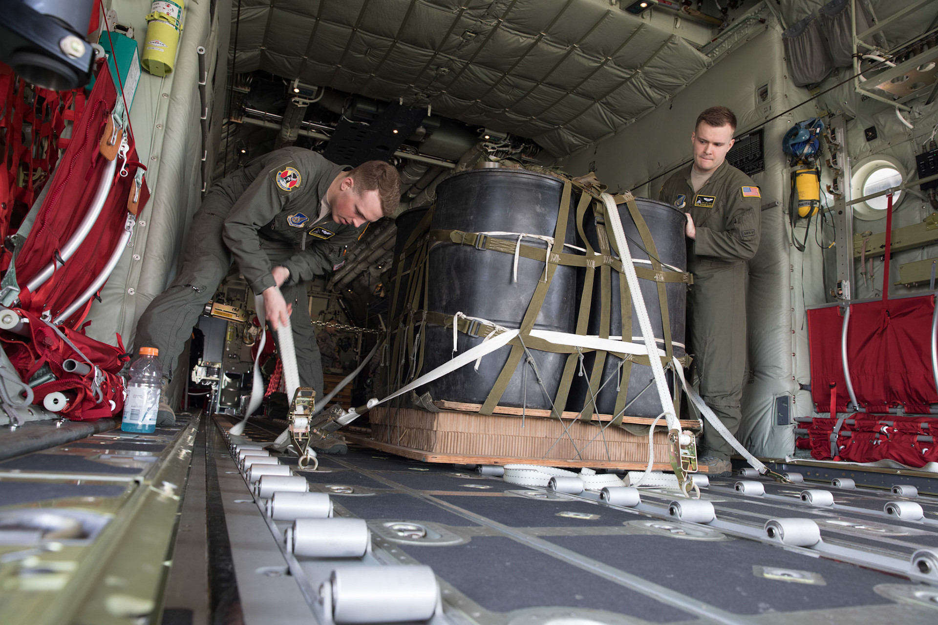 (Left to right) Airman 1st Class Matthew Pfeffer and Senior Airman Stephen Clark, both 36th Airlift Squadron C-130J loadmasters, secure a Container Delivery System (CDS) bundle onto a C-130J Super Hercules at Yokota Air Base, Japan, March 26, 2018. Three C-130Js assigned to the 36th AS trained on airdropping CDS bundle and heavy equipment pallets over the Combined Arms Training Center (CATC) Camp Fuji. (U.S. Air Force photo by Yasuo Osakabe)