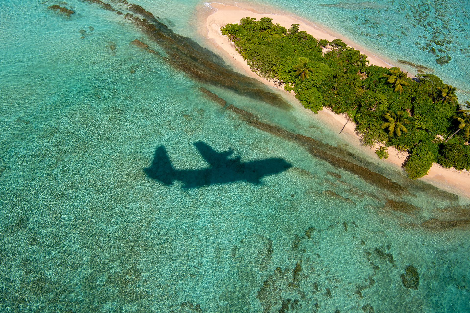 A U.S. Air Force C-130J Super Hercules assigned to the 36th Expeditionary Airlift Squadron maneuvers over Nomwin atoll in the state of Chuuk, Federated States of Micronesia, Dec. 9, 2022, during Operation Christmas Drop 2022. The aircraft, callsign SANTA 67, was the last mission flight of the OCD 2022. (U.S. Air Force photo by Yasuo Osakabe)
