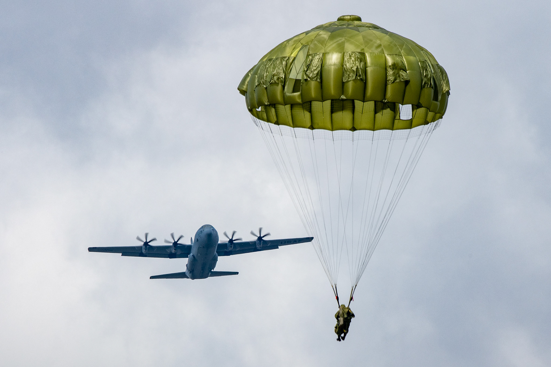 A Japan Ground Self-Defense Force Soldier assigned to the 1st Airborne Brigade descends from a U.S. Air Force C-130J Super Hercules assigned to the 36th Airlift Squadron over JGSDF Narashino Training Area, Japan, April 19, 2022, during a bilateral airborne jump. Ninety-nine JGSDF paratroopers assigned to the 1st Airborne Brigade conducted airborne jump from Two Air Force C-130J Super Hercules. The goal of this event is to improve interoperability between the USAF and JGSDF by defense and information exchanges to deepen mutual understanding of each unit, and to further cement the U.S. and Japanese alliance. (U.S. Air Force photo by Yasuo Osakabe)