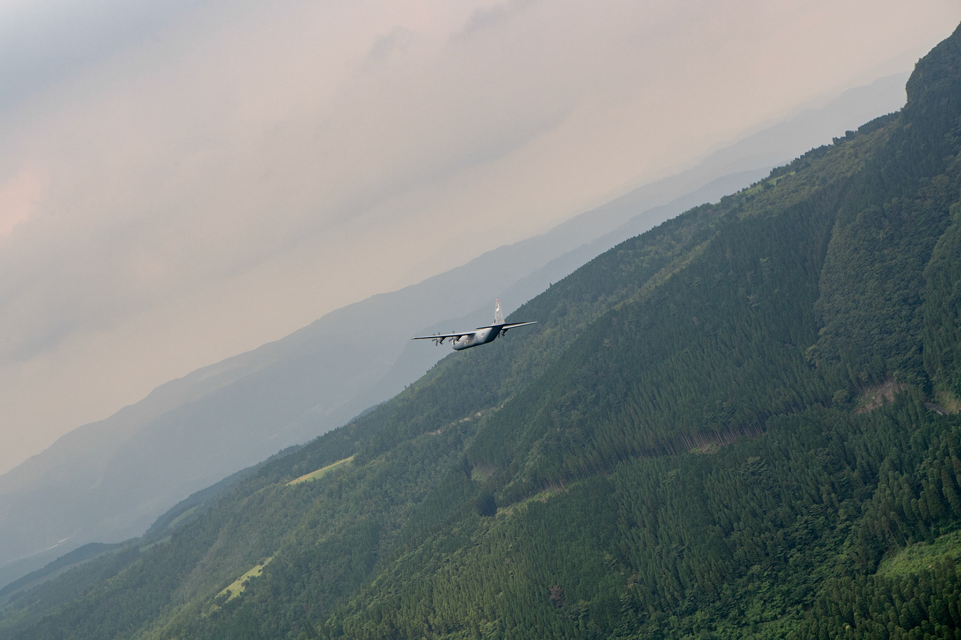 A U.S. Air Force C-130J Super Hercules assigned to the 36th Airlift Squadron conducts flight training over Mount Aso, Japan, July 16, 2019, during a bilateral jump training. The training allows USAF and JGSDF units to work alongside each other while improving the readiness of our armed forces. (U.S. Air Force photo by Yasuo Osakabe)