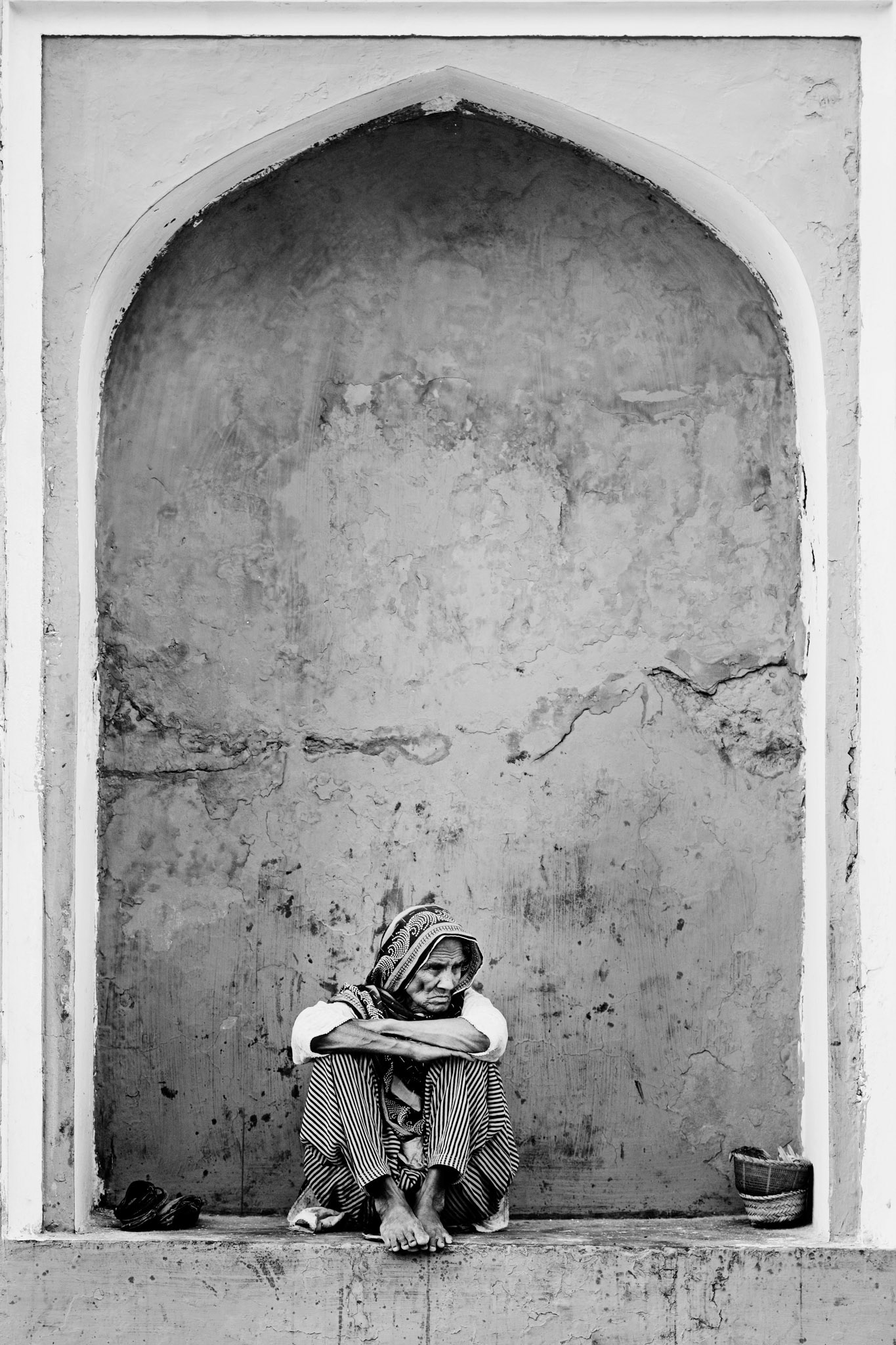 A old woman had sit wistfully down at the Mian Meer darbar at dusk. (Travel)