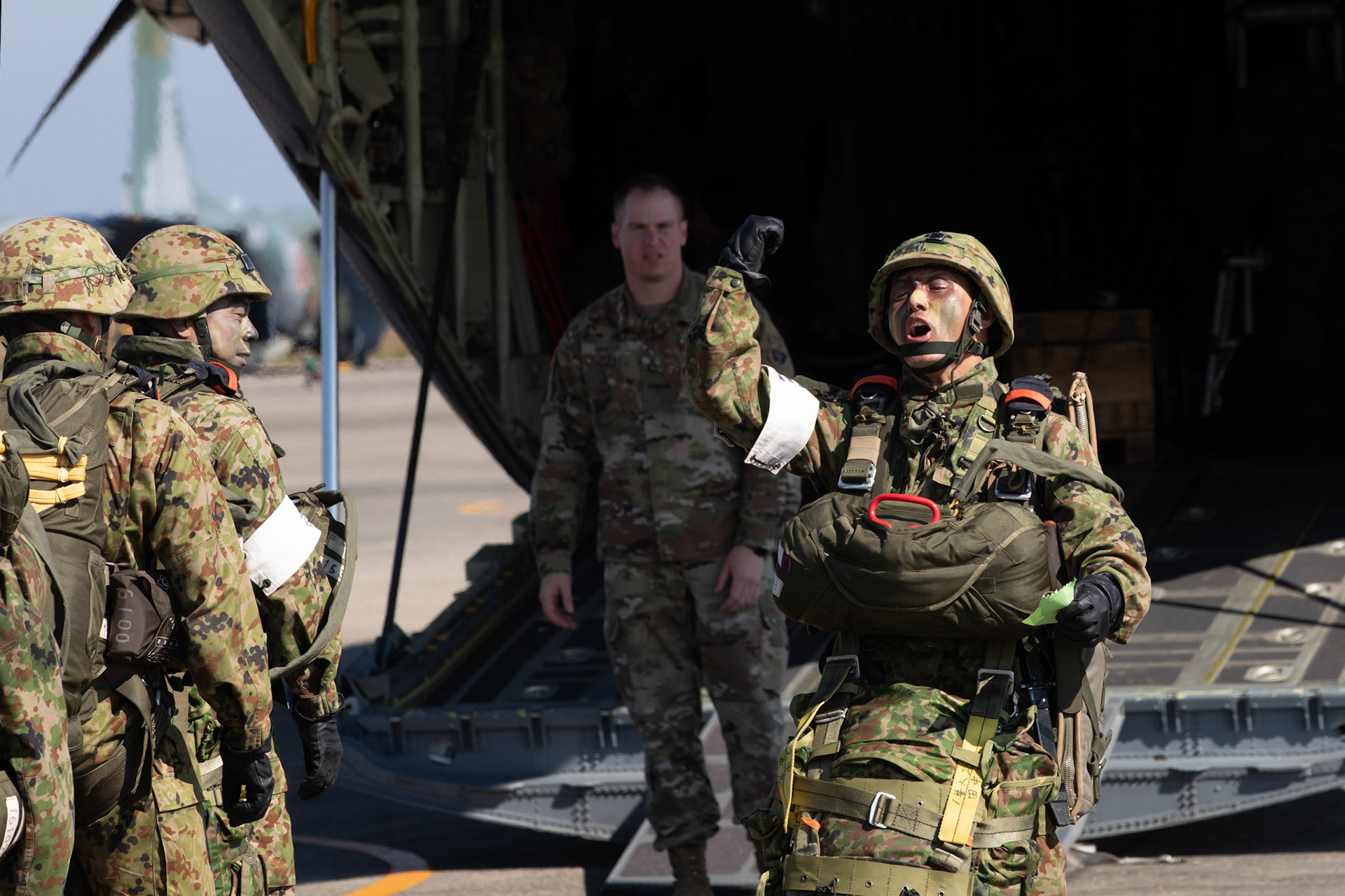 A Japan Ground Self-Defense Force soldier assigned to the 1st Airborne Brigade, calls boarding to a U.S. Air Force C-130J Super Hercules assigned to the 36th Airlift Squadron at Japan Air Self-Defense Force Tsuiki Air Base, Japan, Nov. 4, 2018, during Keen Sword 19. Air Force C-130J Super Hercules’ with the 36 AS became the first U.S. aircraft to drop JGSDF soldiers on Hiju-dai drop zone, Oita prefecture, Japan. (U.S. Air Force photo by Yasuo Osakabe)