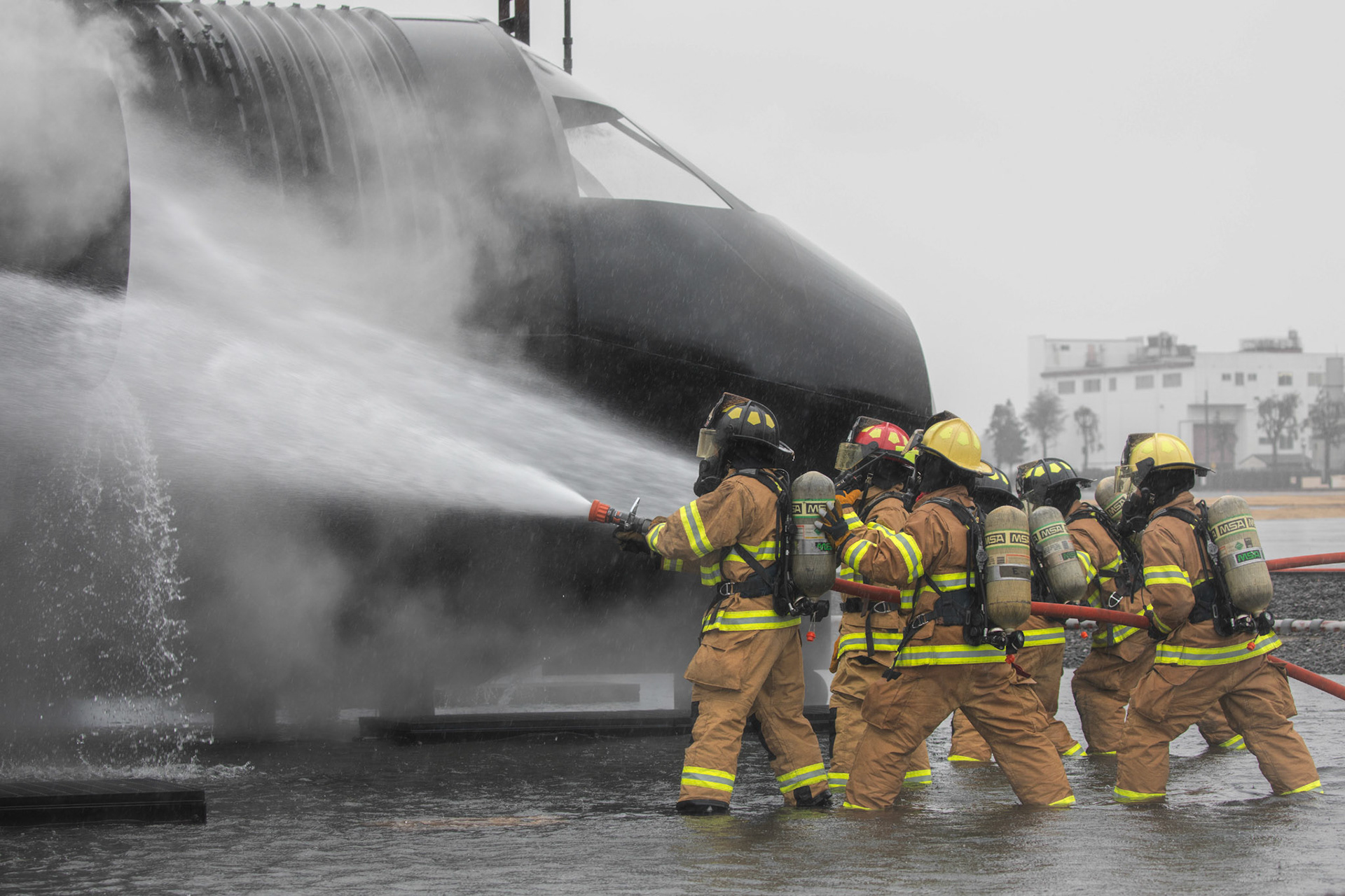 Firefighters with the 374th Civil Engineer Squadron fire and emergency services battle a simulated aircraft fire during a live-fire training at Yokota Air Base, Japan, March 8, 2018. Aircraft live-fire training is conducted periodically throughout the year to ensure Airmen and civilians with the 374th CES and 374th Maintenance Squadron repair and reclamation section are always prepared to combat aircraft fuel fires. (U.S. Air Force photo by Yasuo Osakabe)