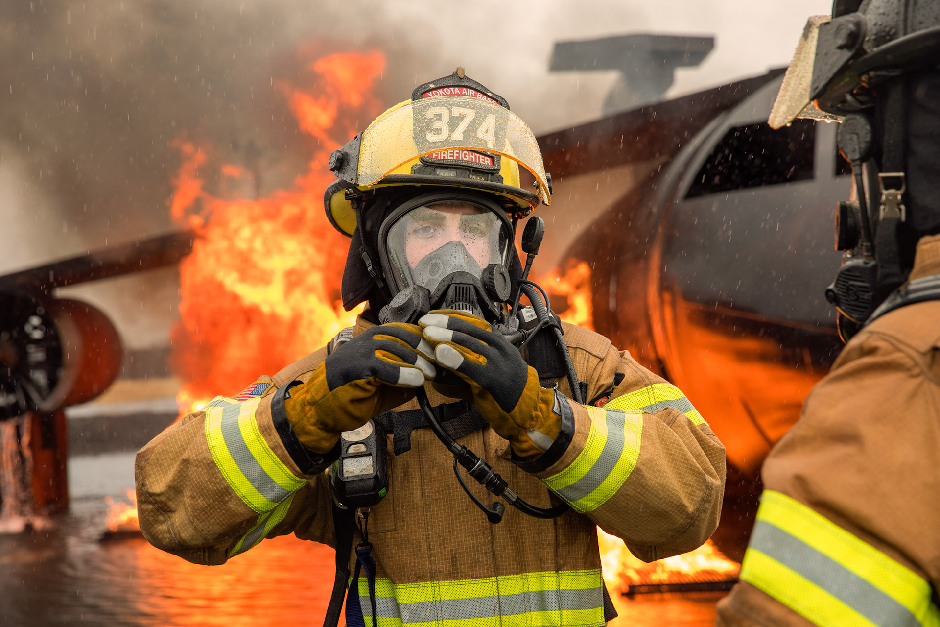 Airman 1st Class Jade Strofaci, 374th Civil Engineer Squadron firefighter, secures his protective gear before conducting a simulated aircraft fire drill at Yokota Air Base, Japan, March 8, 2018.  The Yokota Fire Department and the 374th Maintenance Squadron repair and reclamation section joined forces to prepares for the possibility of an aircraft fire. (U.S. Air Force photo by Yasuo Osakabe)