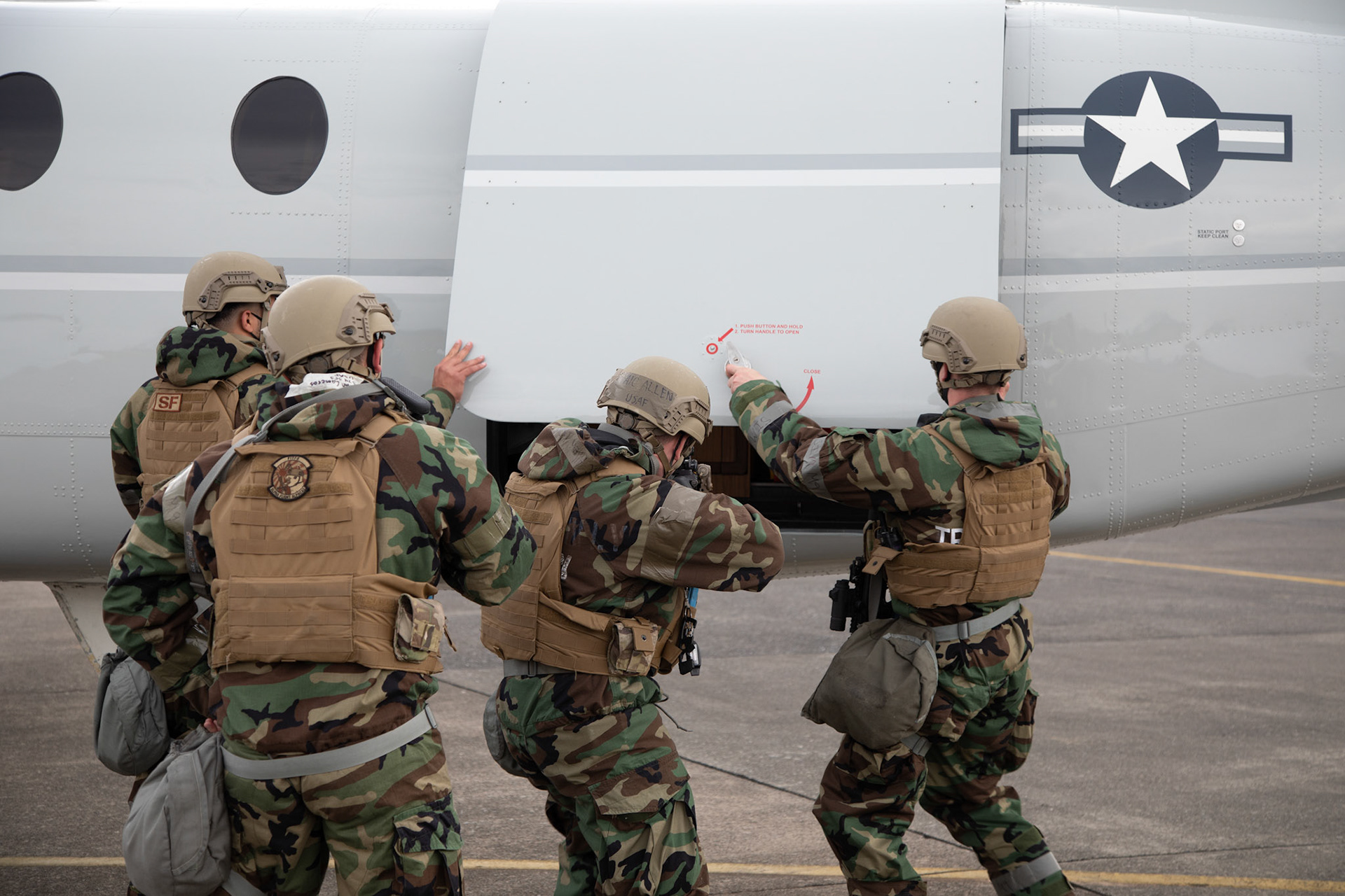 Patrolmen with the 374th Security Forces Squadron open a rear door of a C-12 Huron during an anti-hijacking exercise at Yokota Air Base, Japan, May 5, 2021. Team Yokota members participated in a two-week-long Samurai Readiness Inspection exercise which ensures the base is ready to respond to potential contingencies in the area. (U.S. Air Force photo by Yasuo Osakabe)
