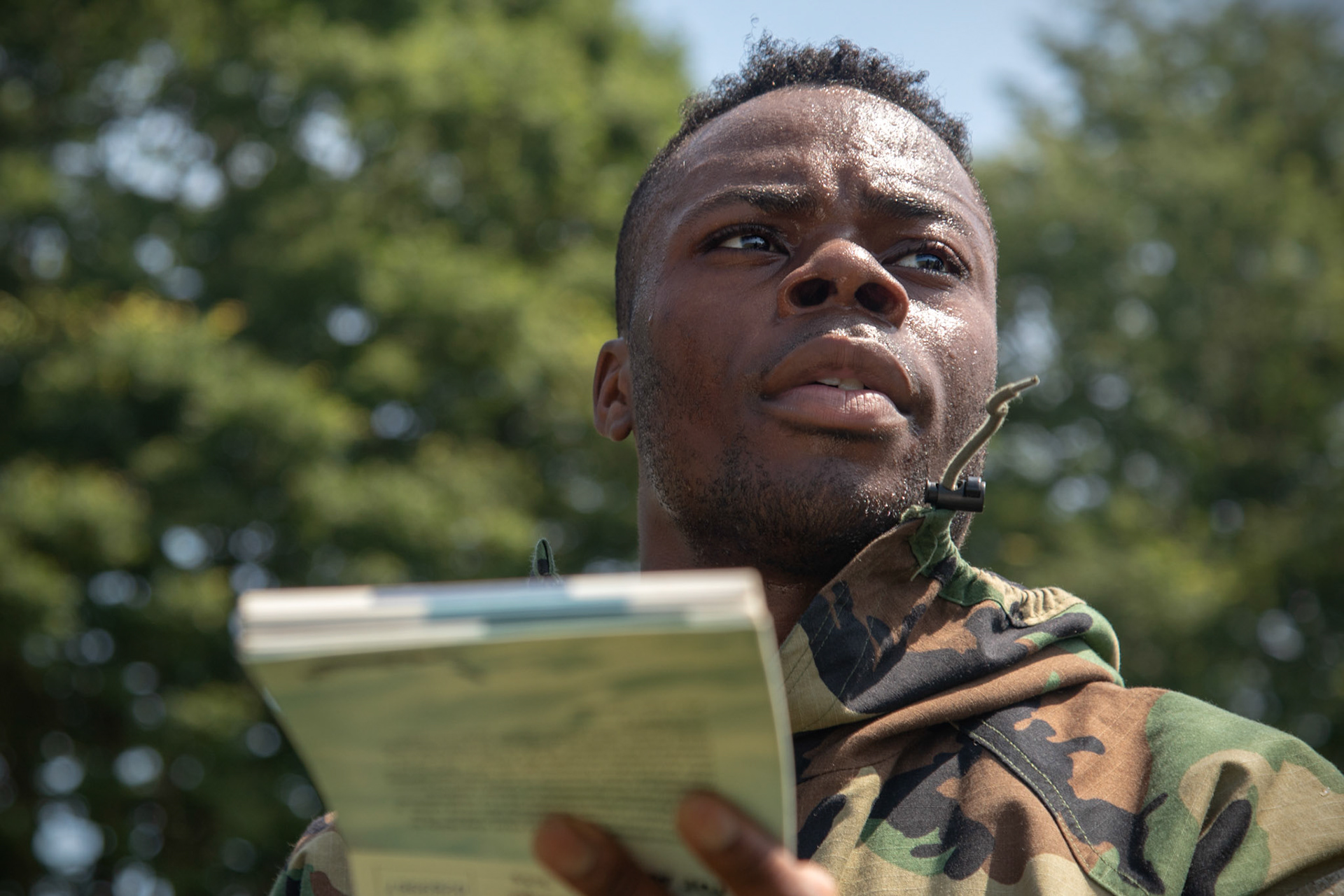 Senior Airman Felix Nunez, 374th Civil Engineer Squadron electrical system technician, glances through his Airman's Manual before performing a post-attack reconnaissance during an Ability to Survive and Operate (ATSO) Rodeo at Yokota Air Base, Japan, June 8, 2018. The rodeo involved participants wearing different stages of mission-oriented protective posture (MOPP) gear after pushing a Humvee and going through various areas of training including self-aid and buddy care, post-attack reconnaissance, four-person relay, and "shoot, move and communicate." (U.S. Air Force photo by Yasuo Osakabe)