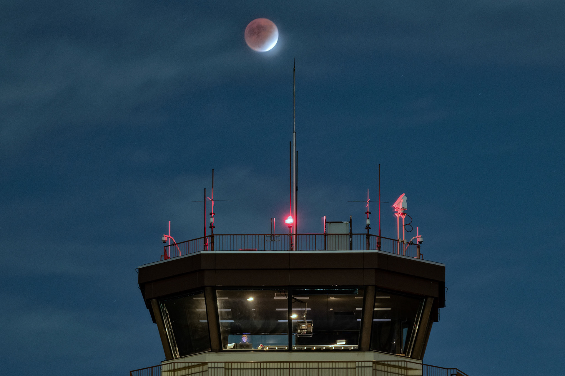 The moon sits in partial lunar eclipse over the Yokota control tower at Yokota Air Base, Japan, Nov. 19, 2021. The Moon passes into the shadow of the Earth, creating a partial lunar eclipse so deep that it can reasonably be called almost total. (U.S. Air Force photo by Yasuo Osakabe)