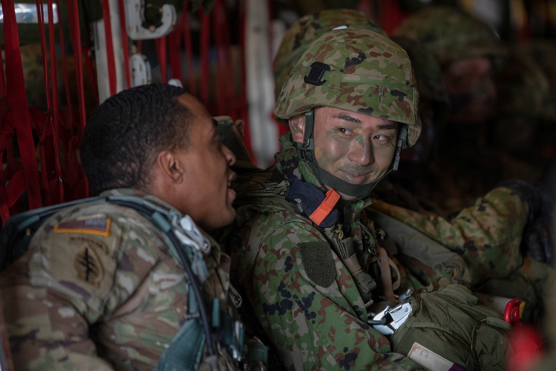 U.S. Army Staff Sgt. Kevin Stewart, U.S. Army Alaska jump master, talks to a Japan Ground Self-Defense Force soldier assigned to the 1st Airborne Brigade at Japan Air Self-Defense Force Tsuiki Air Base, Japan, Nov. 4, 2018, during Keen Sword 19. Air Force C-130J Super Hercules’ from the 36 AS became the first U.S. aircraft to drop JGSDF soldiers on Hiju-dai drop zone, Oita prefecture, Japan. (U.S. Air Force photo by Yasuo Osakabe)