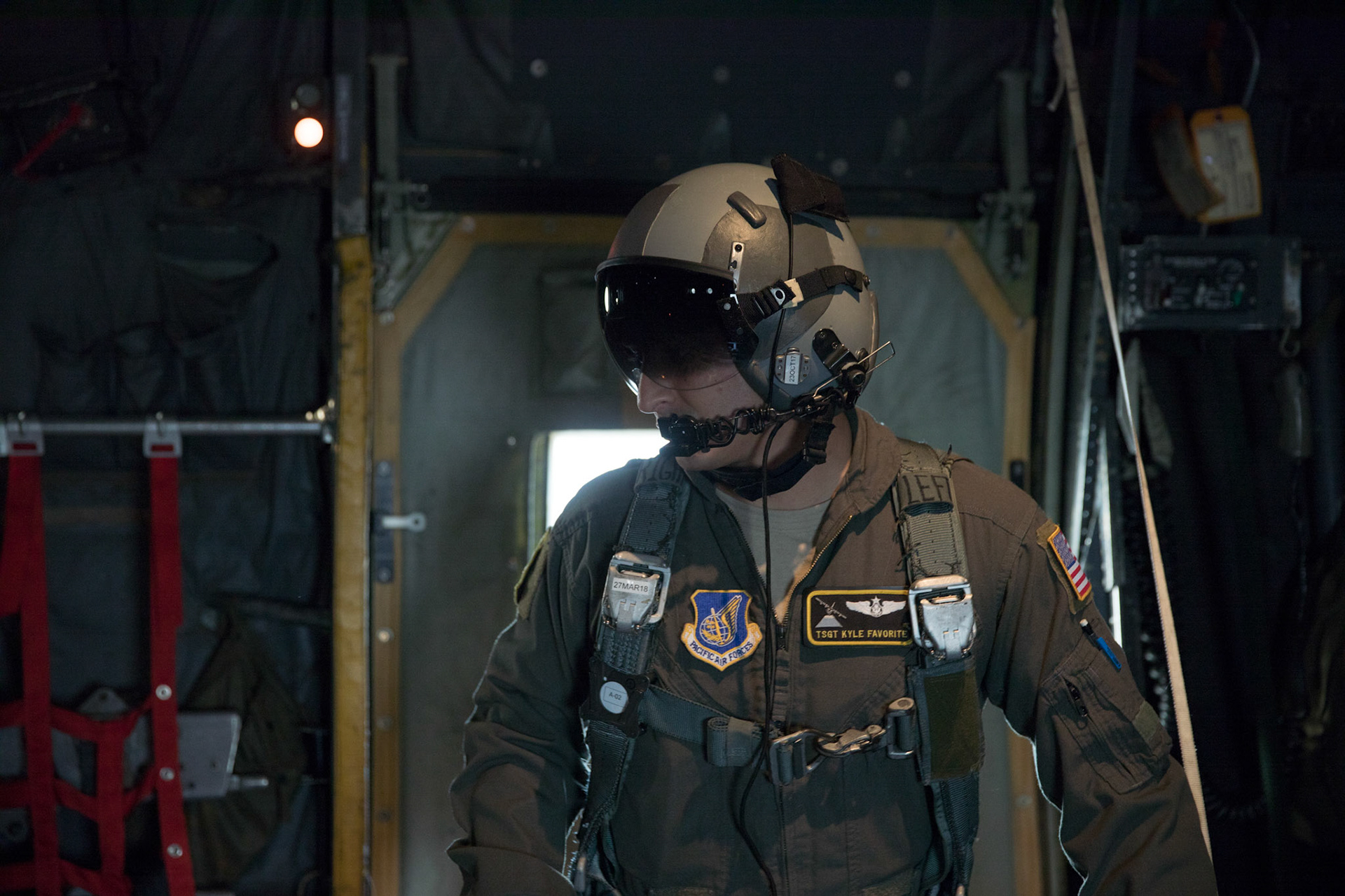 Tech. Sgt. Kyle Favorite, 36th Airlift Squadron C-130H loadmaster, communicates with crew members on a C-130H Hercules after executing a low-cost, low-altitude airdrop training over Yokota Air Base, Japan, Oct. 5, 2017. This is the last time active duty C-130H Hercules' crew members perform an LCLA airdrop. (U.S. Air Force photo by Yasuo Osakabe)