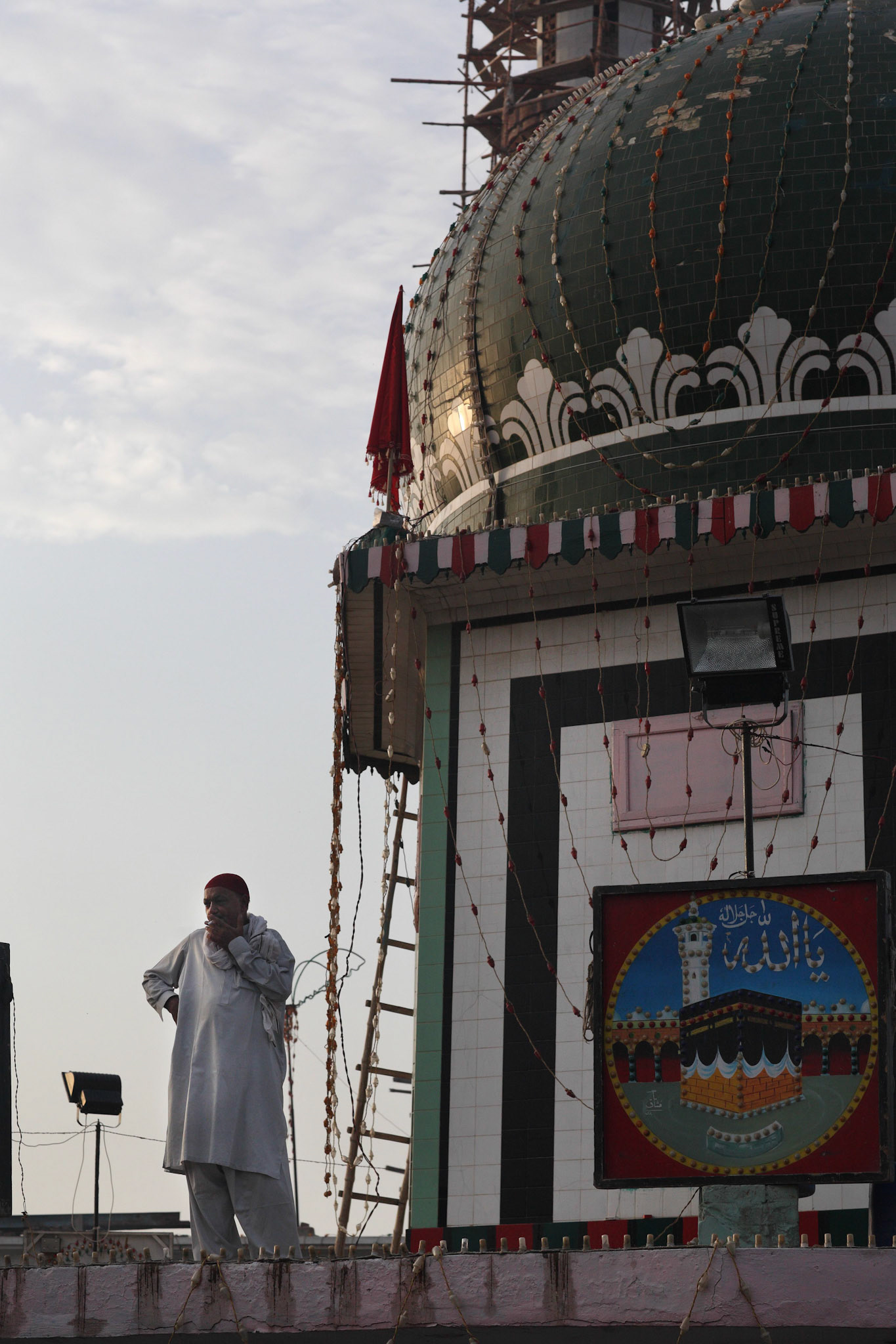 The person who maintains the darbar took a break on the roof top at Patoki city, Punjab, Pakistan. (Travel)