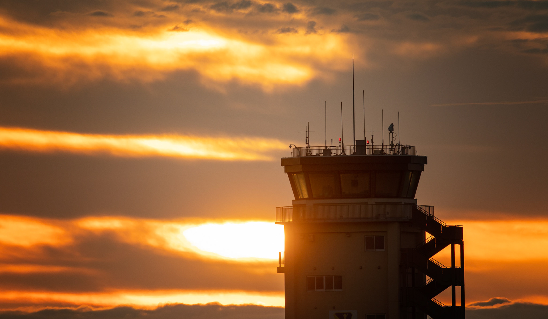 The sun rises over the Air Traffic Control Tower at Yokota Air Base, Japan, June 12, 2020. Air traffic controllers with the 374th Operations Support Squadron report for duty before an airfield opening. Responsible for managing the flow of aircraft through all aspects of their flight, ATC specialists ensure the safety and efficiency of air traffic on the ground and in the air. (U.S. Air Force photo by Yasuo Osakabe)