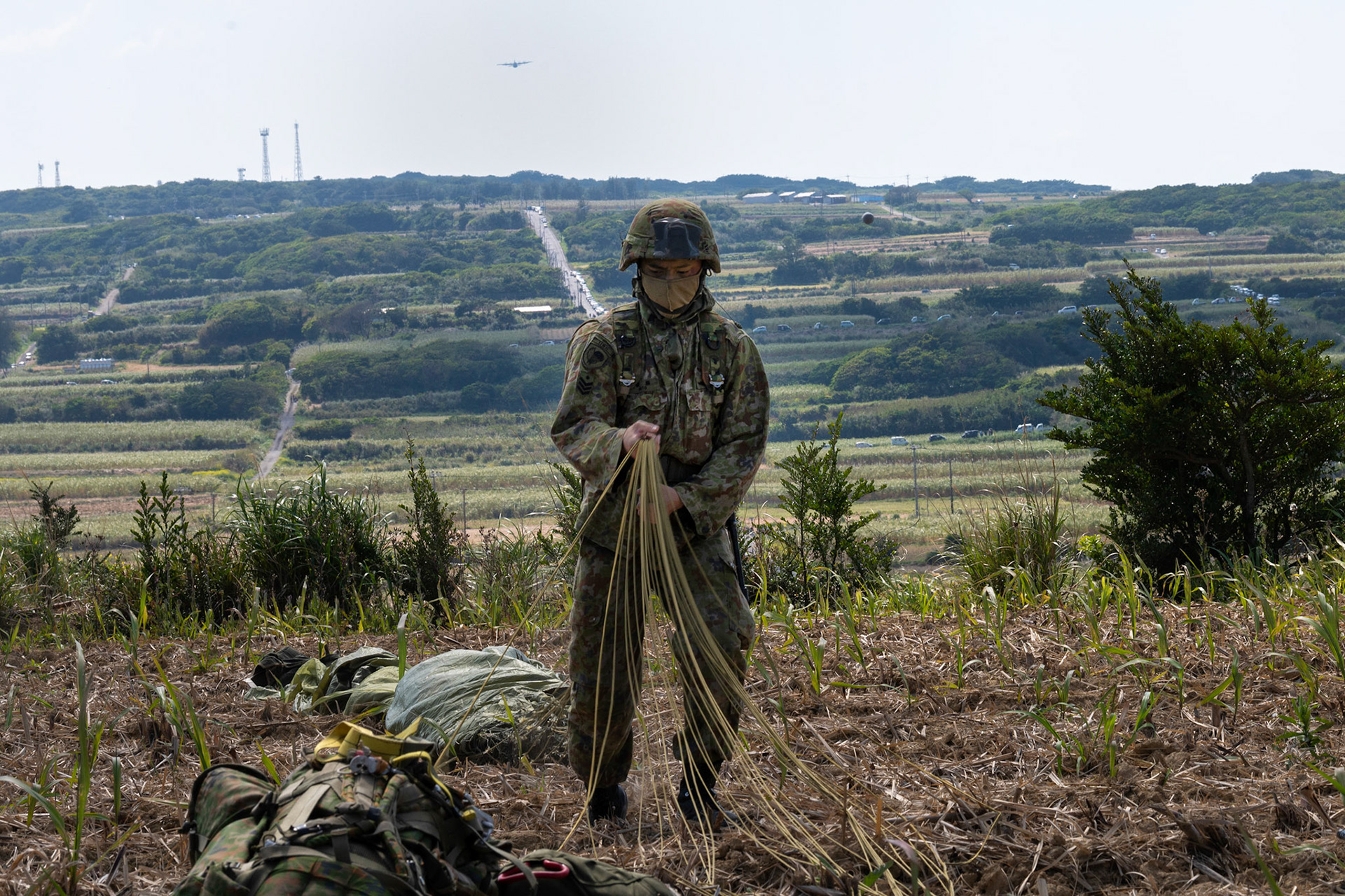 A Japan Ground Self-Defense Force paratrooper assigned to the 1st Airborne Brigade packs his parachute after completing a static-line jump during Field Training Exercise Iron Fist 23 at Kikaijima Island, Japan, March 3, 2023. During the exercise, the USAF and Japan Self-Defense Forces conducted simulated island seizure airborne operations as the U.S. Marine Corps performed a simultaneous amphibious assault onto the beachhead. (U.S. Air Force photo by Yasuo Osakabe)