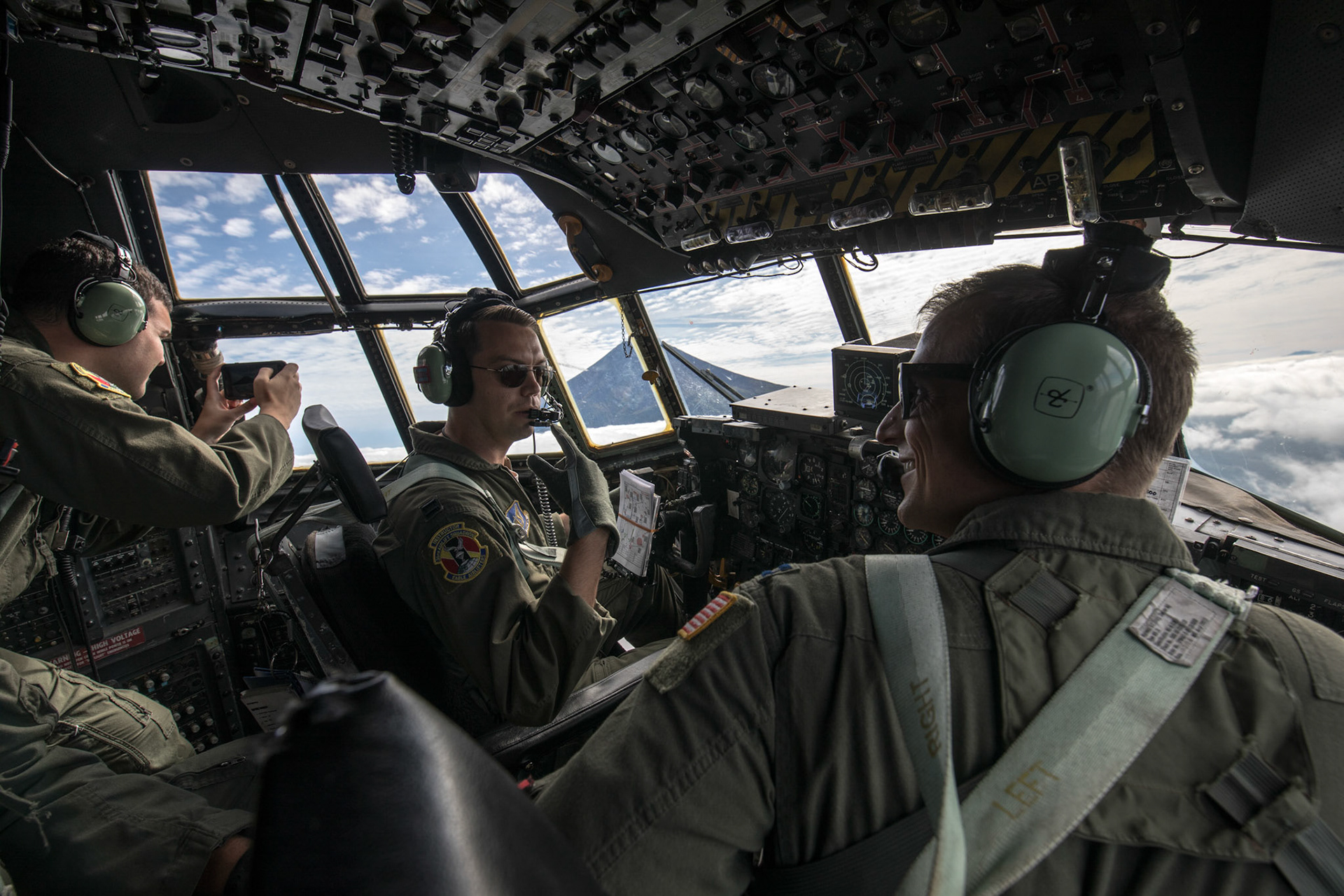 Crew members with the 36th Airlift Squadron communicate during a training mission near Mount. Fuji, Japan, Oct. 5, 2017. This is the last active duty C-130H Hercules tactical training sortie. (U.S. Air Force photo by Yasuo Osakabe)
