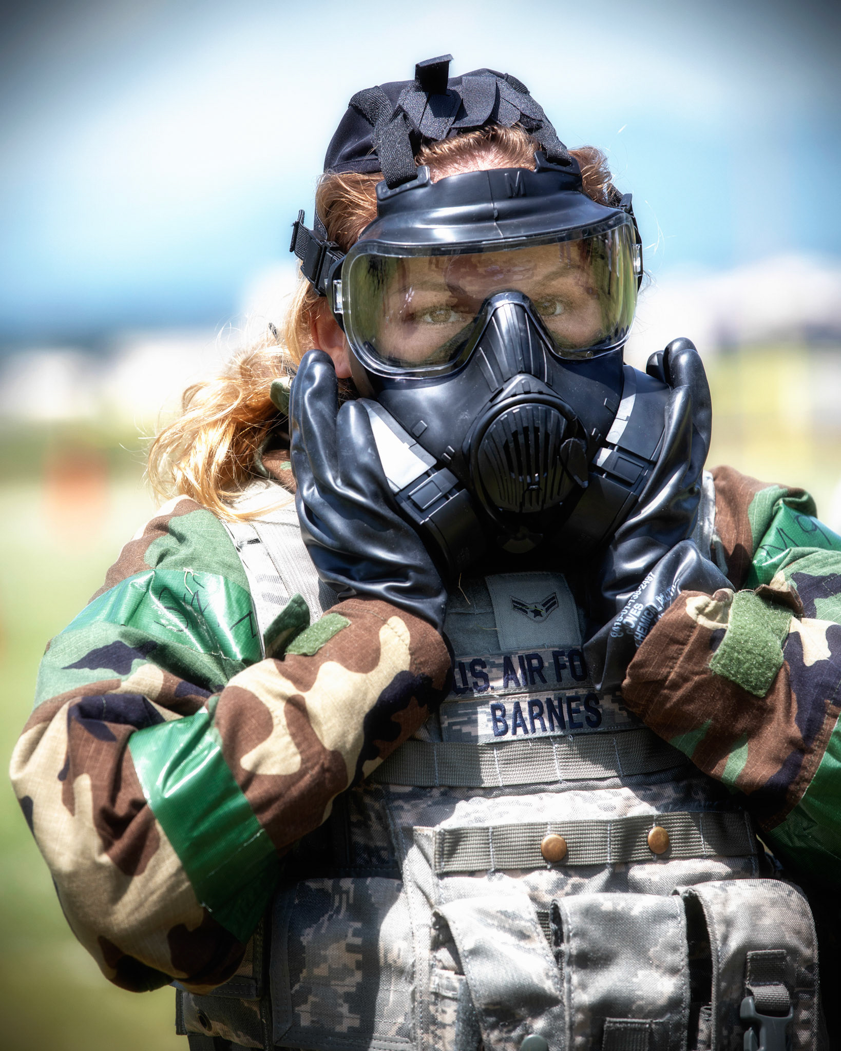 Airman 1st Class Hannah Barnes, 374th Security Forces Squadron patrolman, checks her gas mask seal during an Ability to Survive and Operate (ATSO) Rodeo at Yokota Air Base, Japan, June 8, 2018. The rodeo involved participants wearing different stages of mission-oriented protective posture (MOPP) gear after pushing a Humvee and going through various areas of training including self-aid and buddy care, post-attack reconnaissance, four-person relay, and "shoot, move and communicate." (U.S. Air Force photo by Yasuo Osakabe)