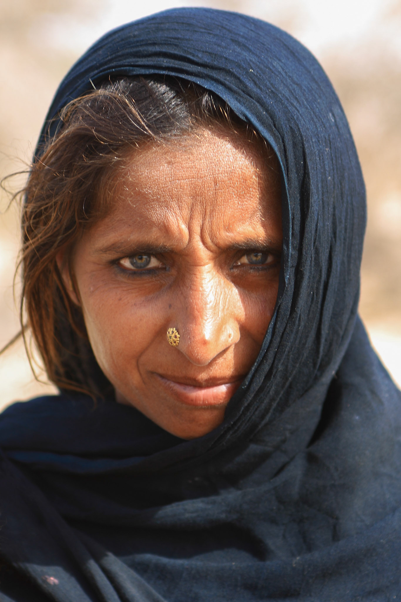Old woman with piercing blue eyes in Cholistan desert. The tribe is still nomadic in Cholistan desert, Pakistan. (Travel)